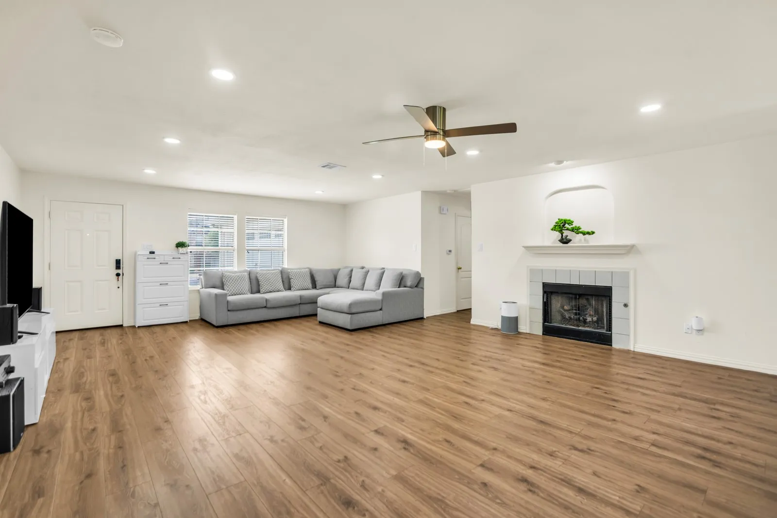 Spacious living area featuring wood-finish flooring, recessed lighting, and a ceiling fan