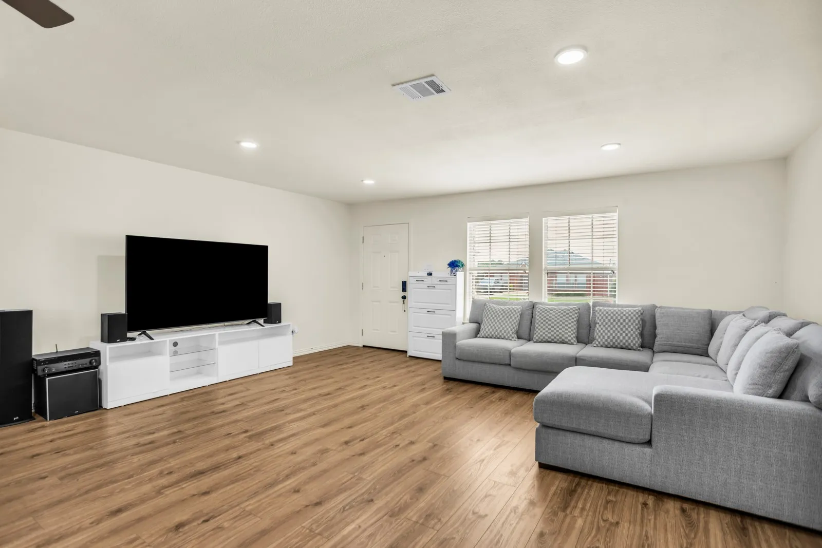 Spacious living area featuring wood-finish flooring, recessed lighting, and a ceiling fan
