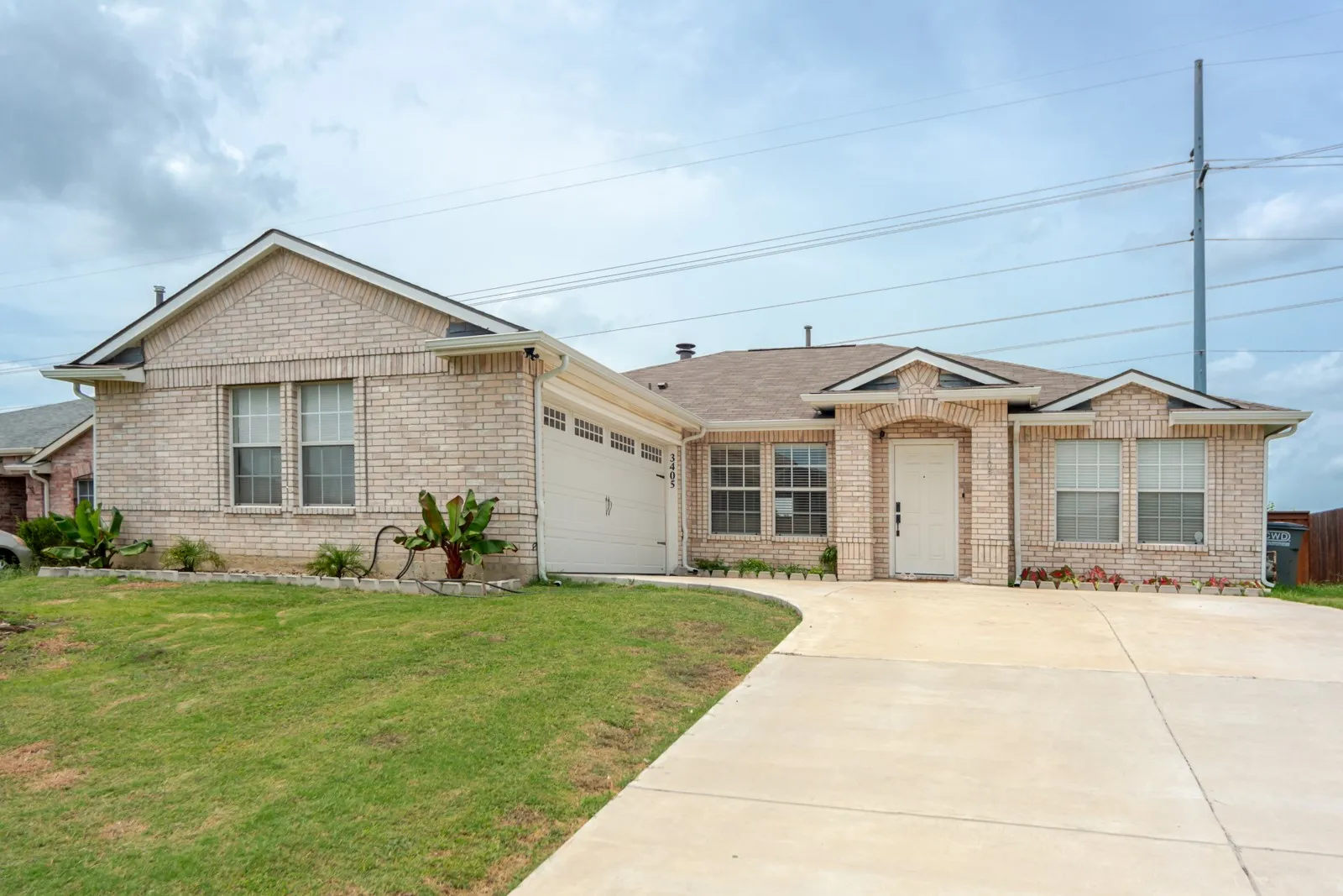 Cream brick exterior featuring multiple gables and a covered front entry