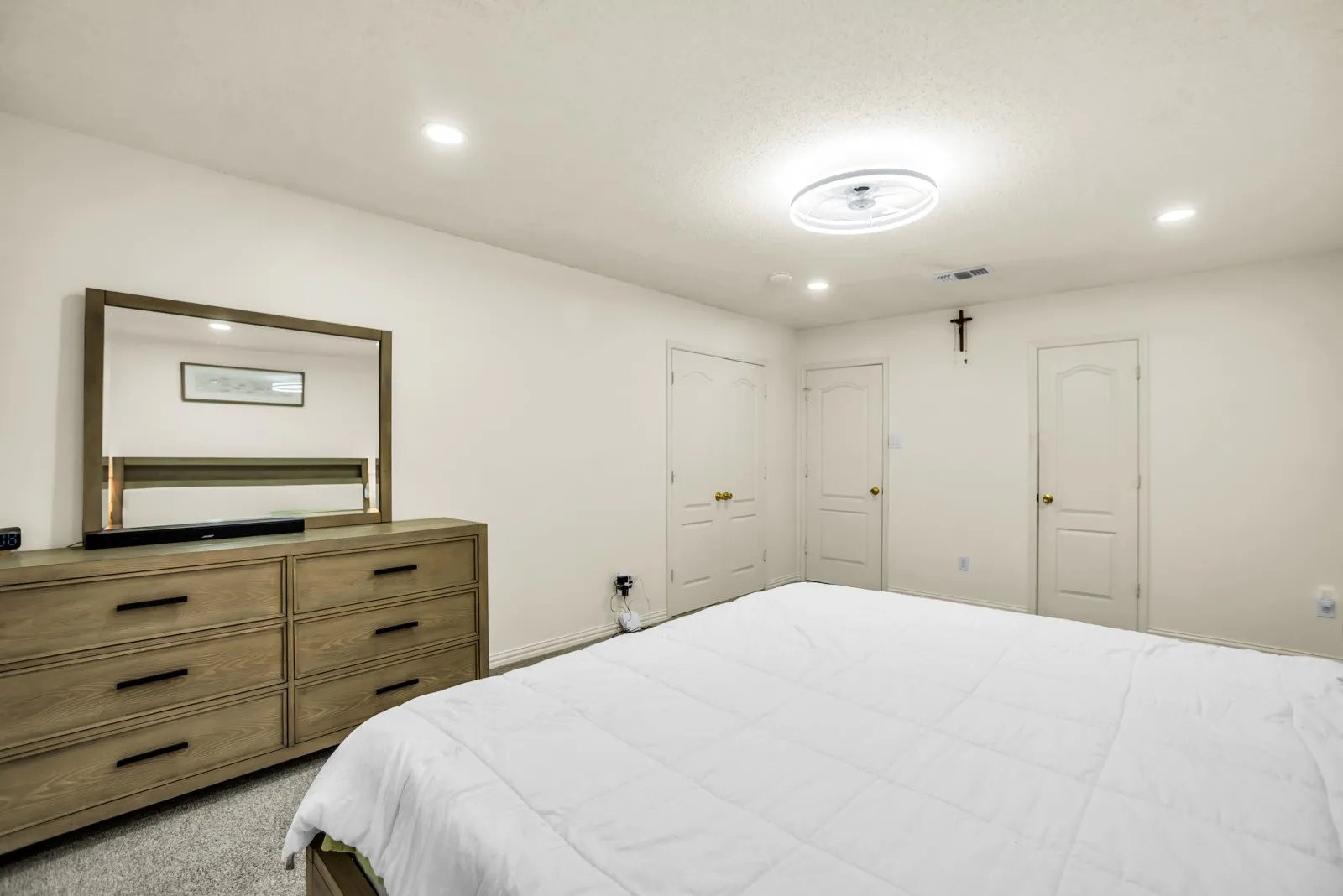 Carpeted room with recessed lighting, a ceiling-mounted light fixture, and multiple white panel doors