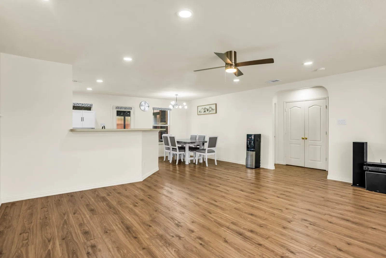 Expansive main living area featuring wood-finish flooring throughout, recessed lighting, and a ceiling fan