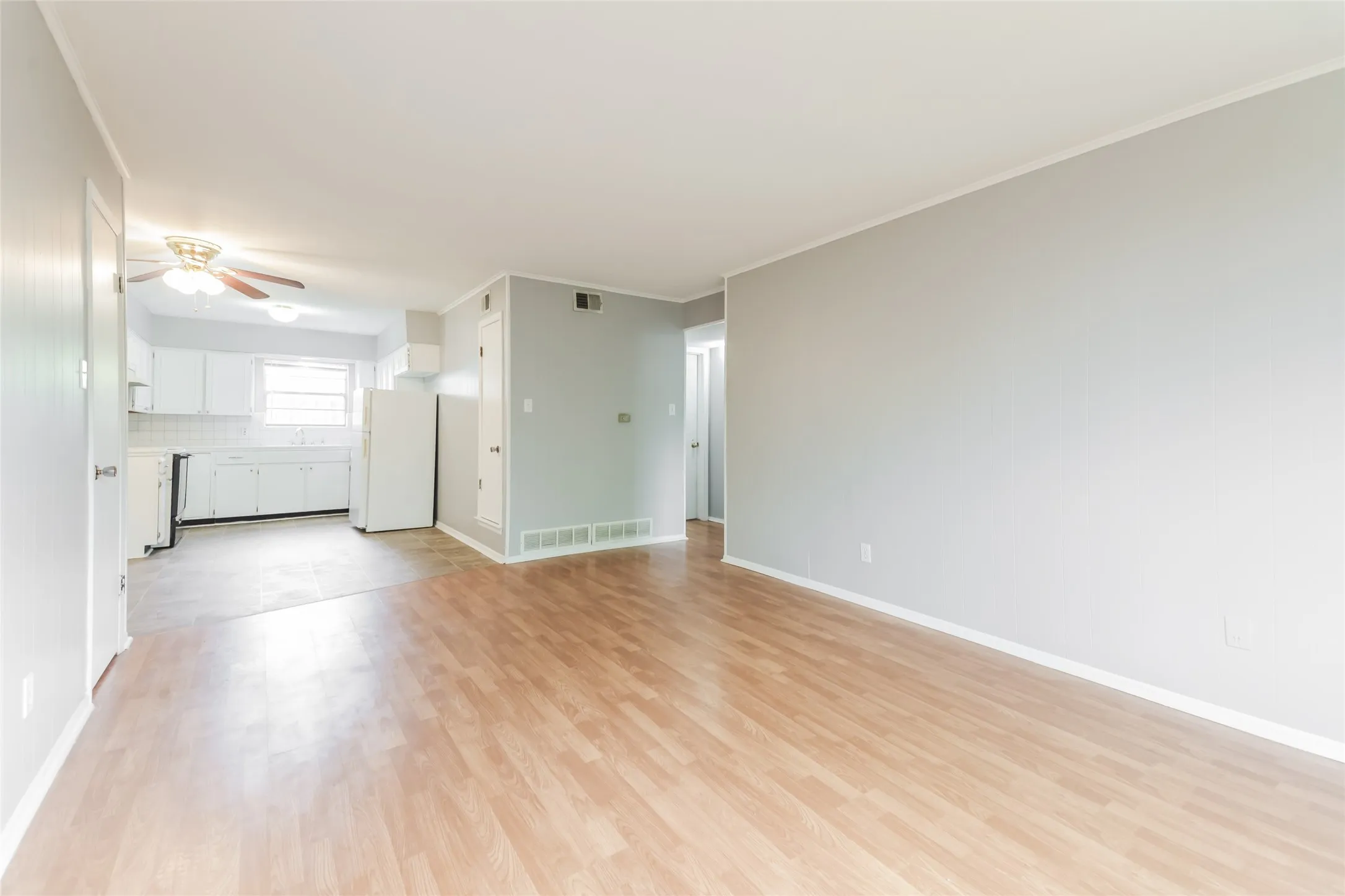 Living area featuring wood-finish flooring, light gray wall paint, and white baseboards
