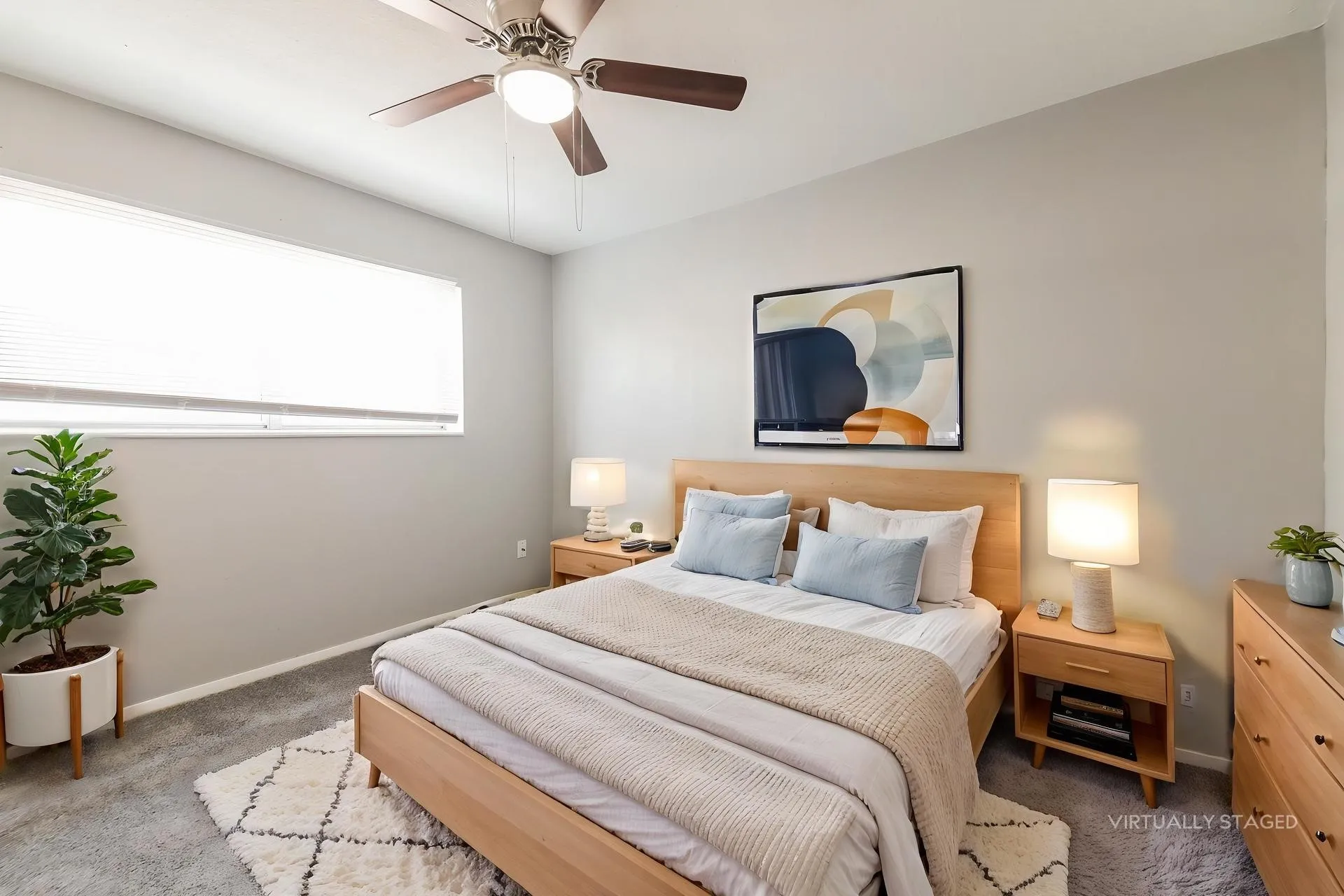 Carpeted room featuring a ceiling fan with light fixture, a wide window with blinds, and light gray wall paint