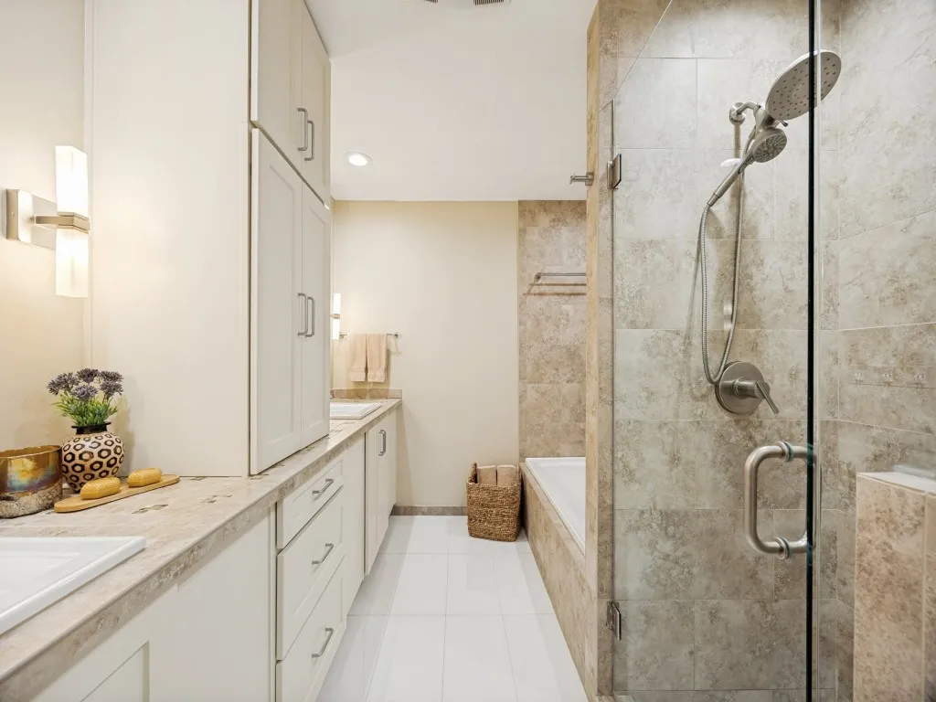 Luxurious updated bathroom includes recently replaced flooring, cabinets, countertops, lighting, and fully updated shower and bath.