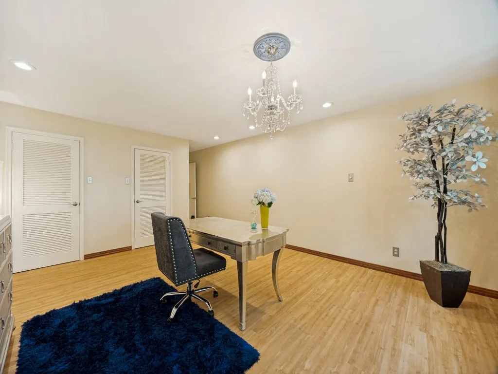 One of the primary bedrooms - this one features double walk-in closets, a view of the courtyard full of mature trees, recent interior paint, and designer wood look flooring.