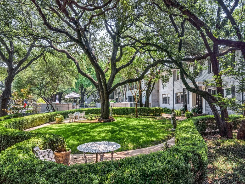 The magnificent trees provide shade throughout the courtyard with sitting areas, walking paths, and views of the pool.