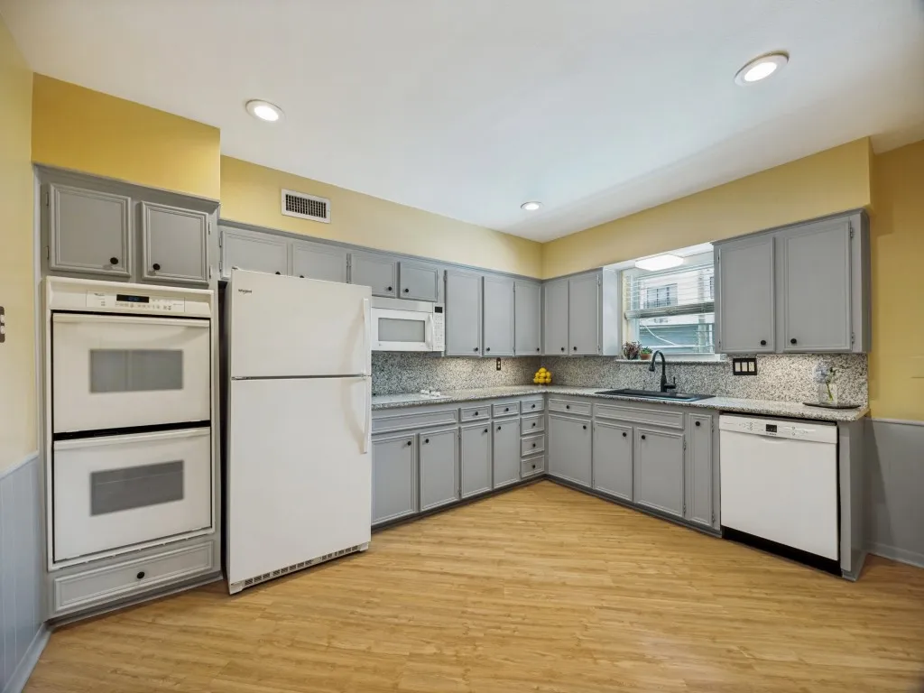 This home features a large living and dining room that flow seamlessly into the large kitchen with double ovens and granite countertops.