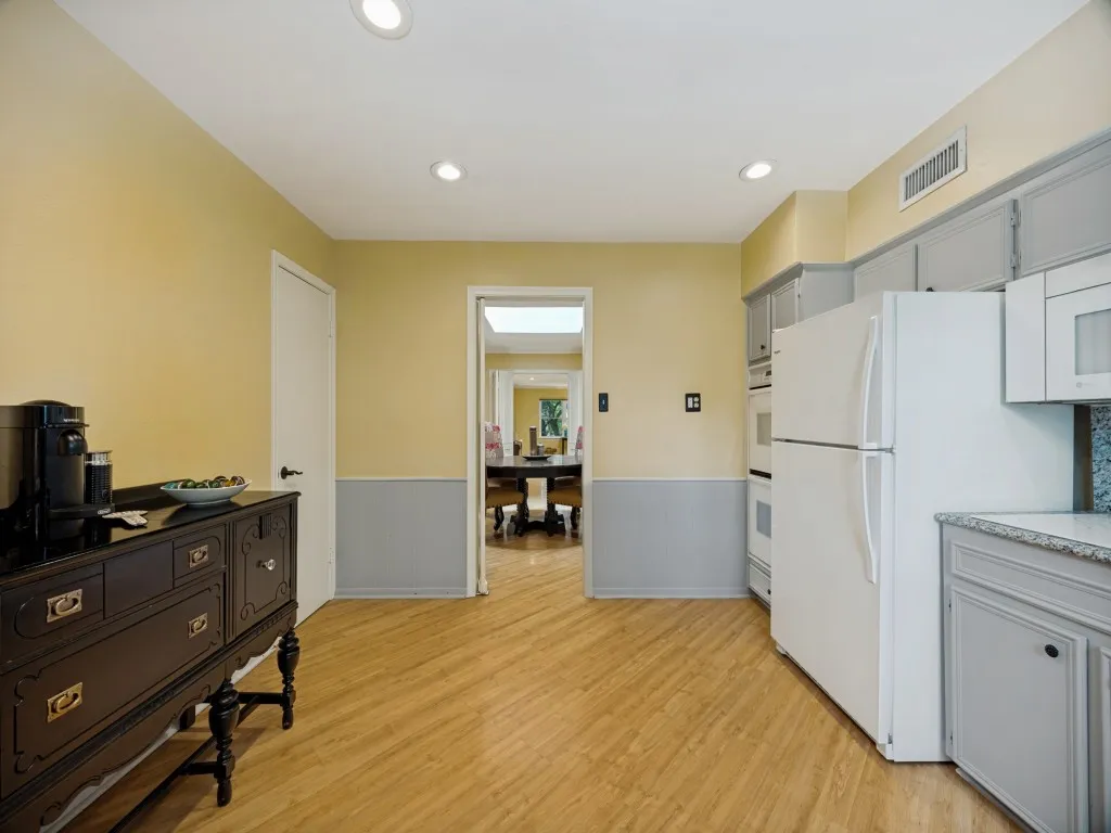 Kitchen with coffee bar has fresh paint, double ovens, Bosch dishwasher, granite counter tops, under cabinet lighting, full pantry, and ample cabinet space.