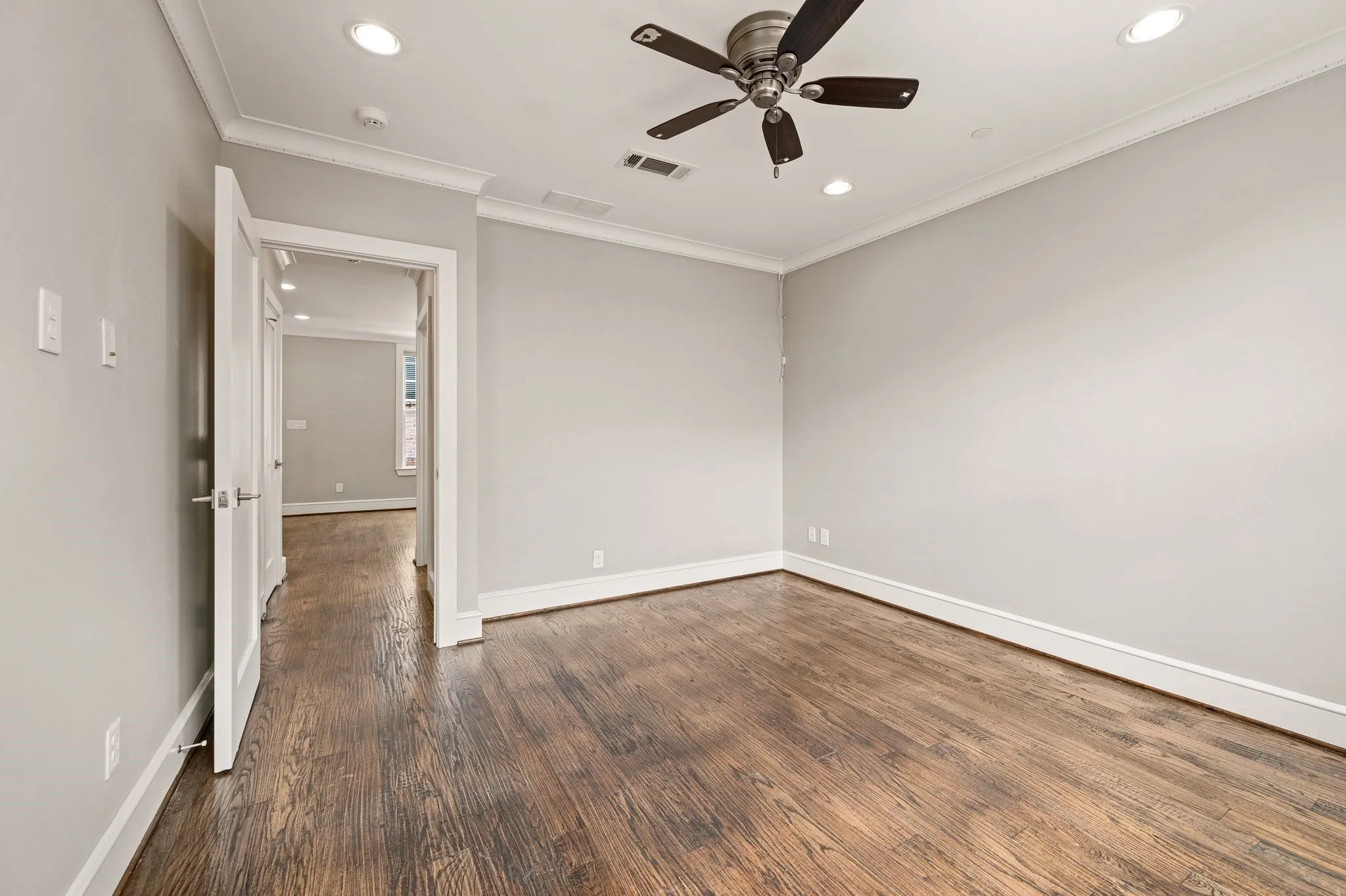 Spacious room featuring wood-finish flooring, recessed lighting, and a ceiling fan