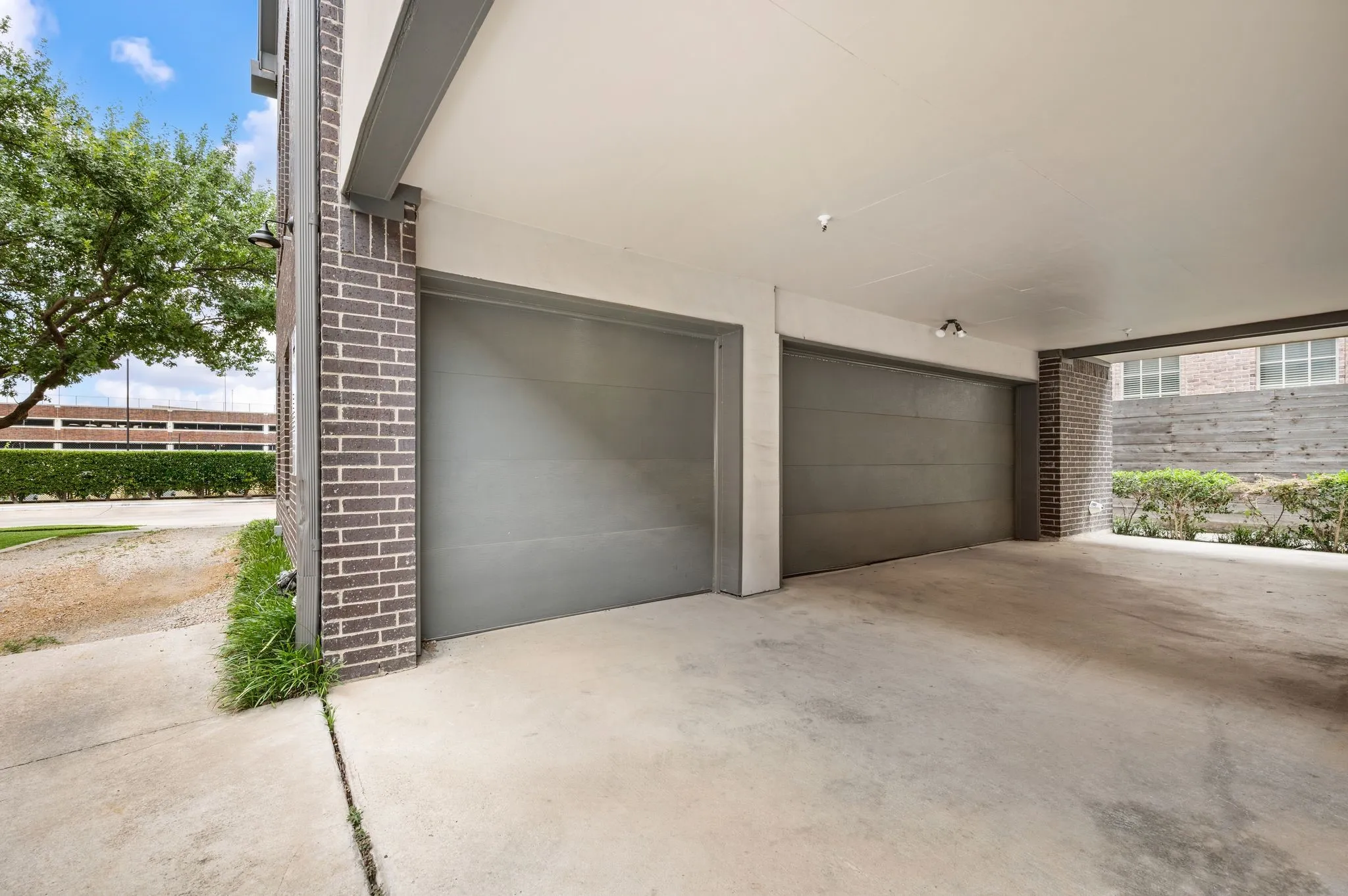 Two single-car garages featuring gray doors and concrete flooring