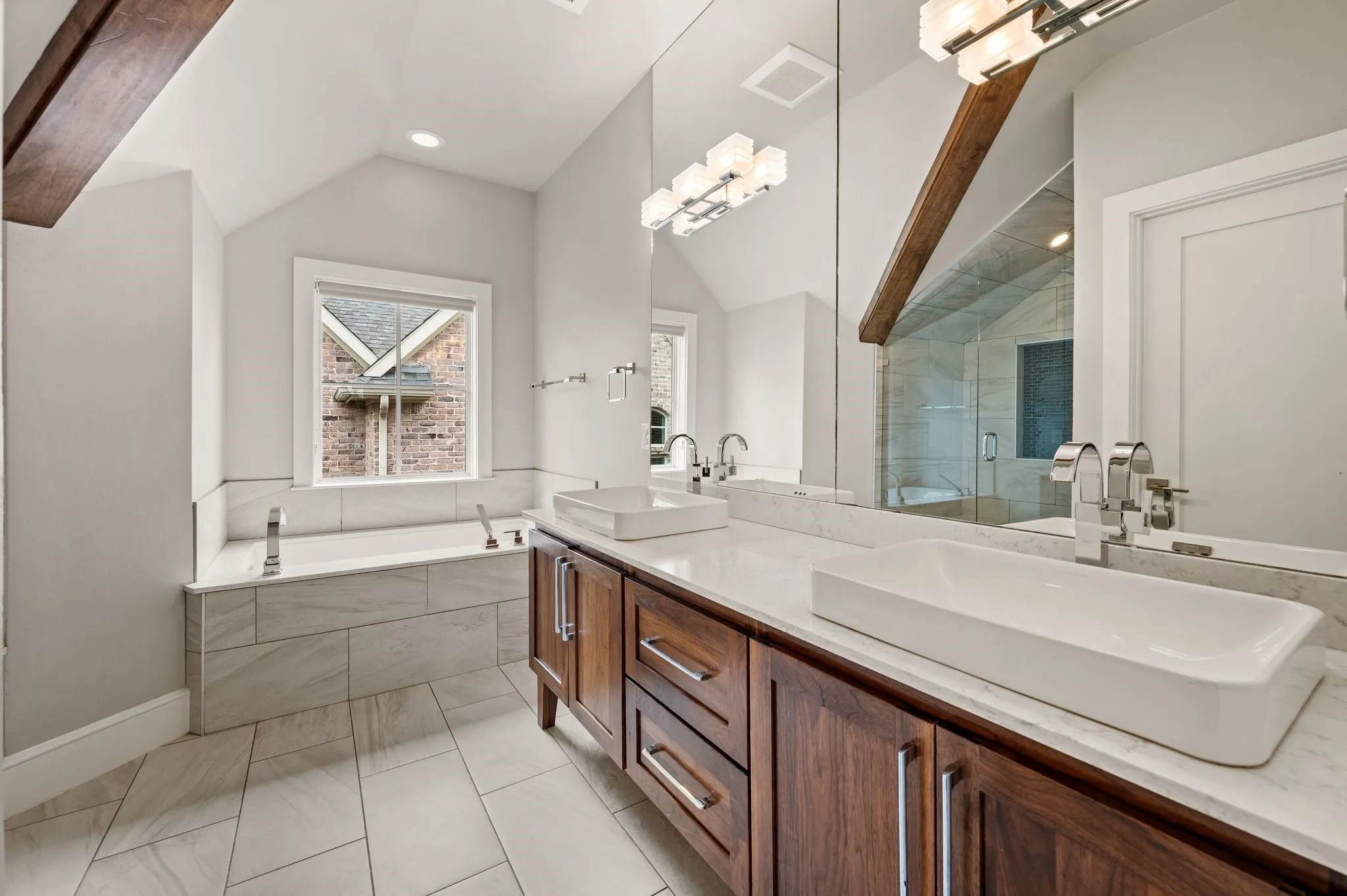 Dual vessel sinks with chrome fixtures set into a marble-finish countertop