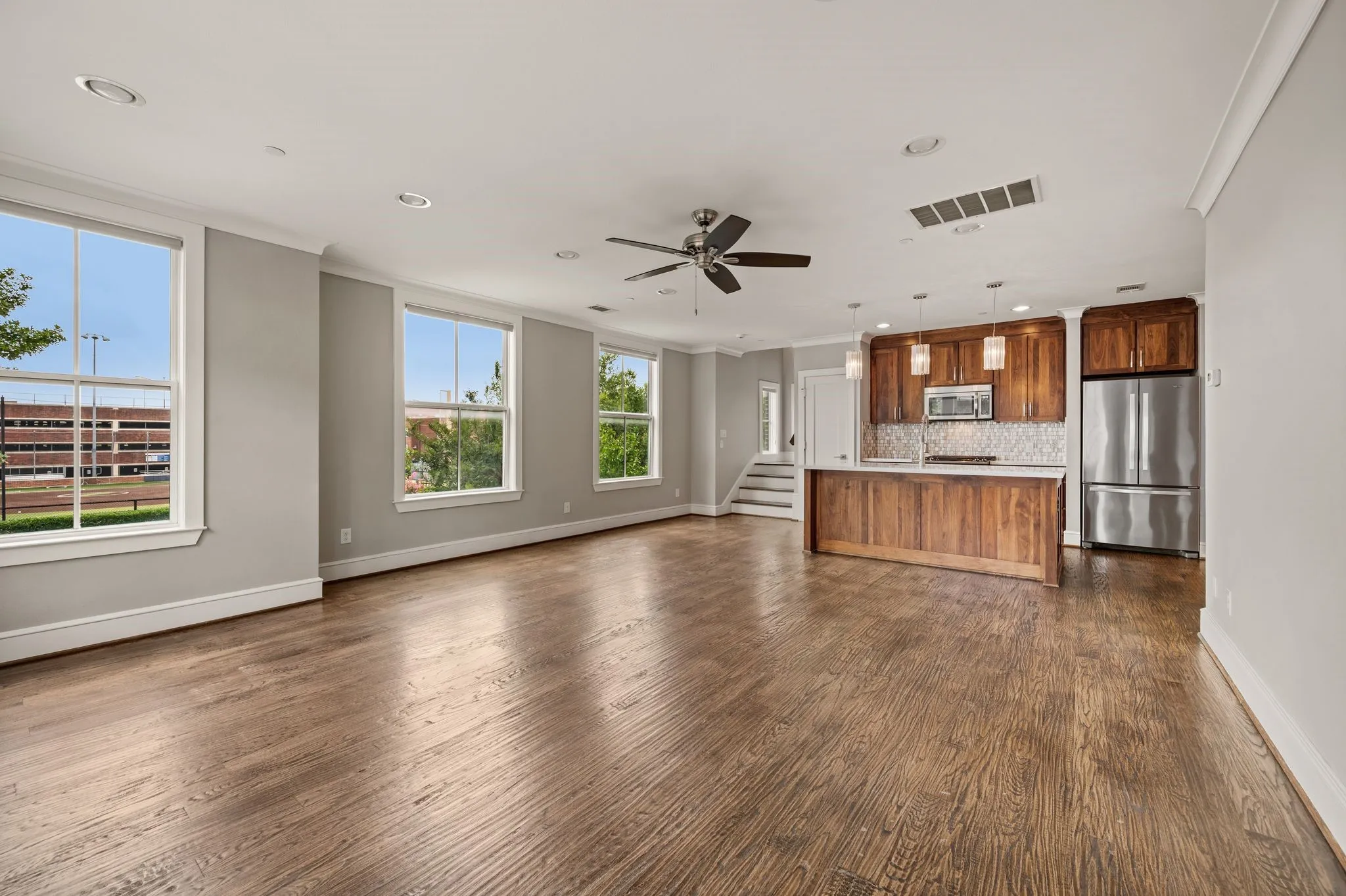 Open concept living space featuring wood-finish flooring, recessed lighting, and a modern ceiling fan