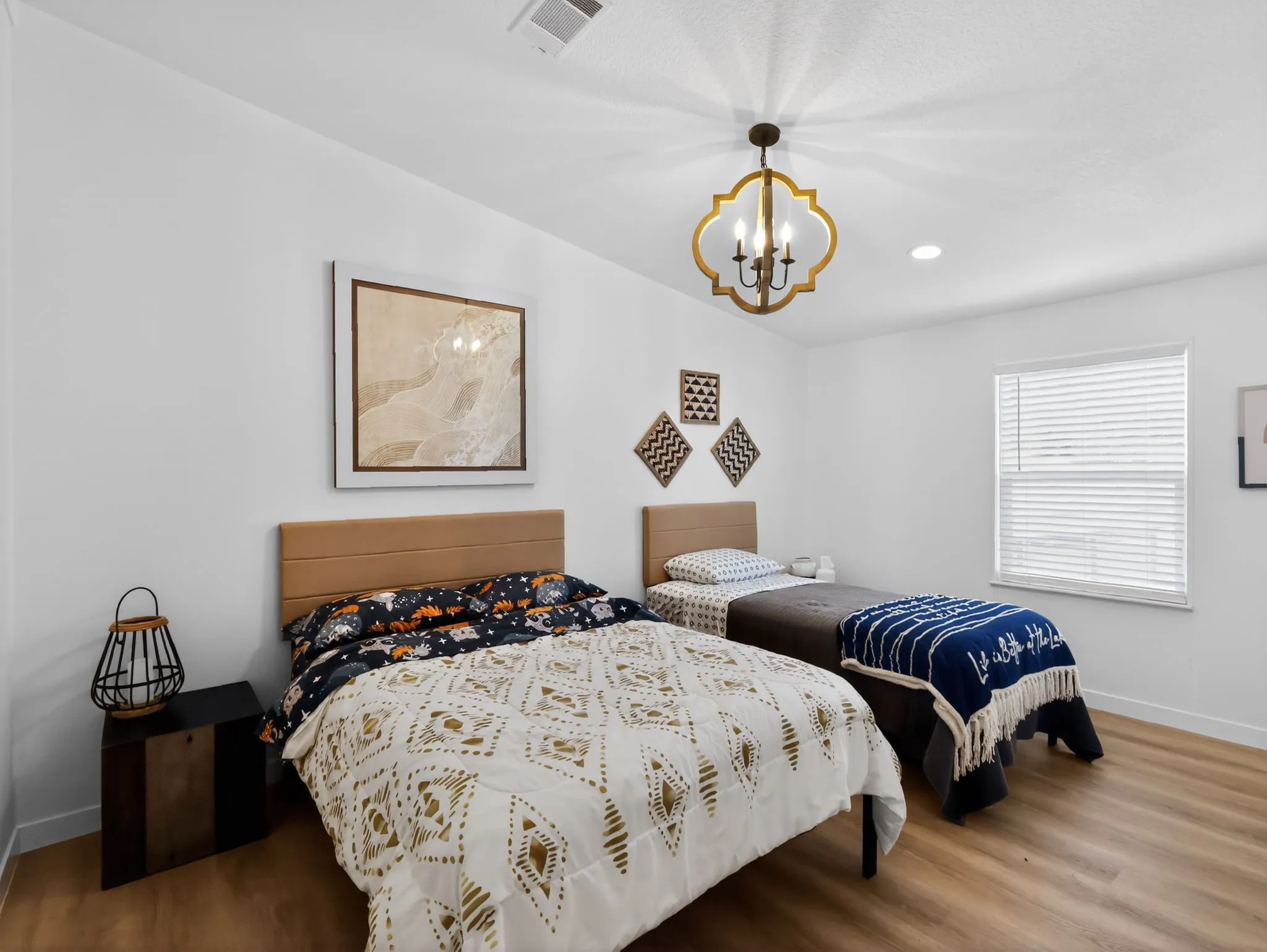 Bright room featuring wood-finish flooring, a contemporary quatrefoil chandelier, recessed ceiling lighting, and a window with blinds