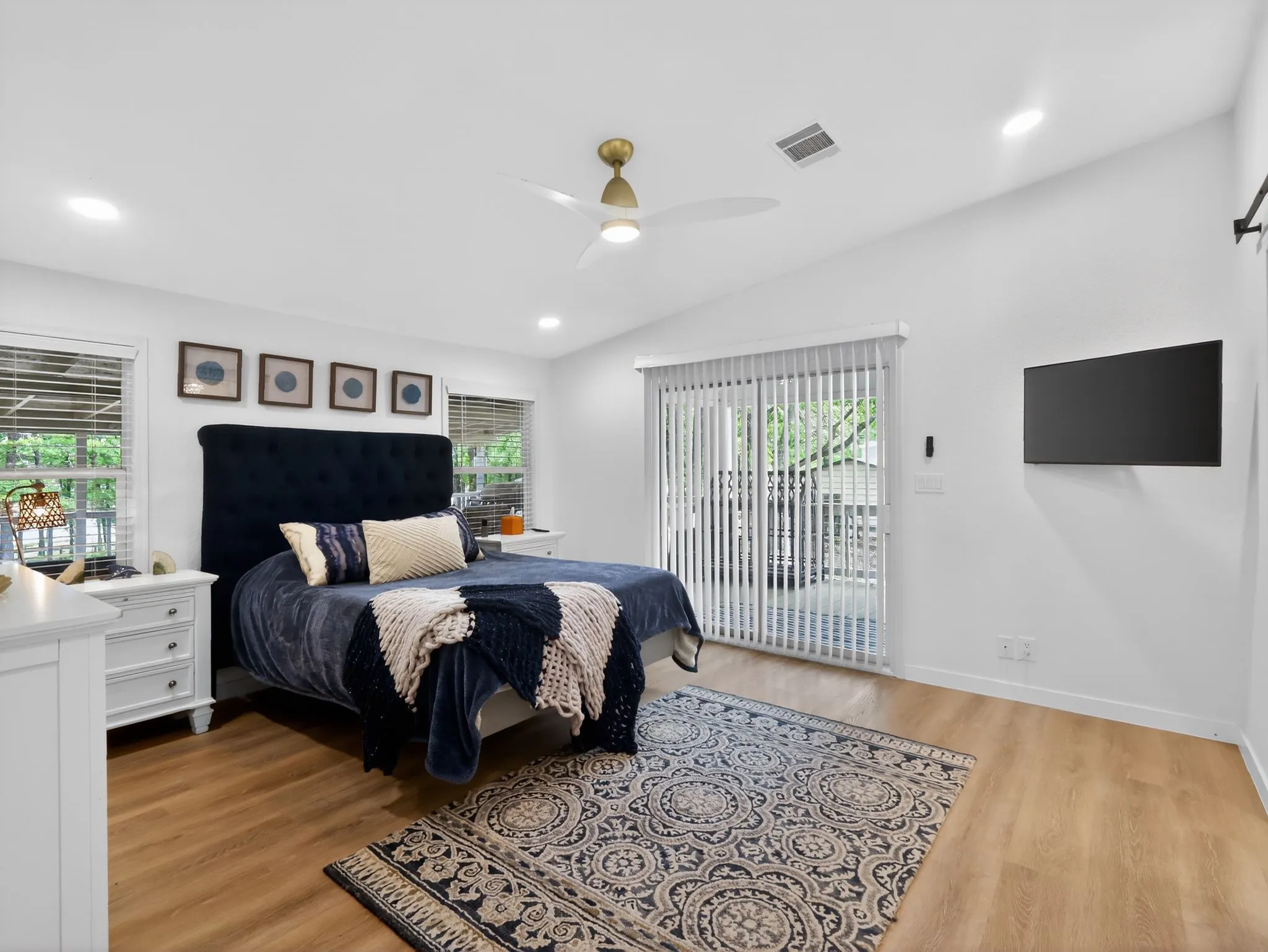 Bright bedroom featuring wood-finish flooring, recessed lighting, and a vaulted ceiling with a modern ceiling fan