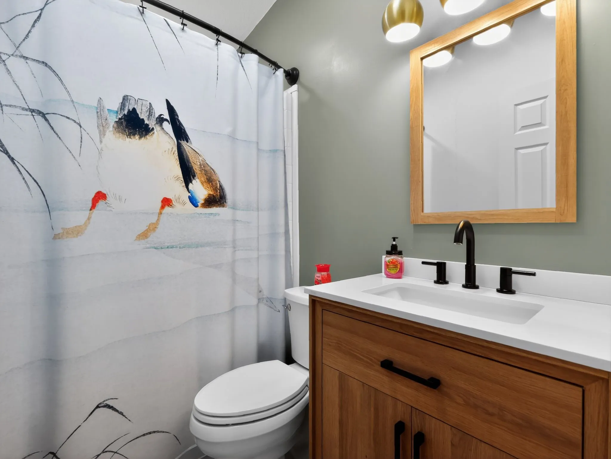 Bathroom featuring a wood-finish vanity with a white countertop and integrated rectangular sink