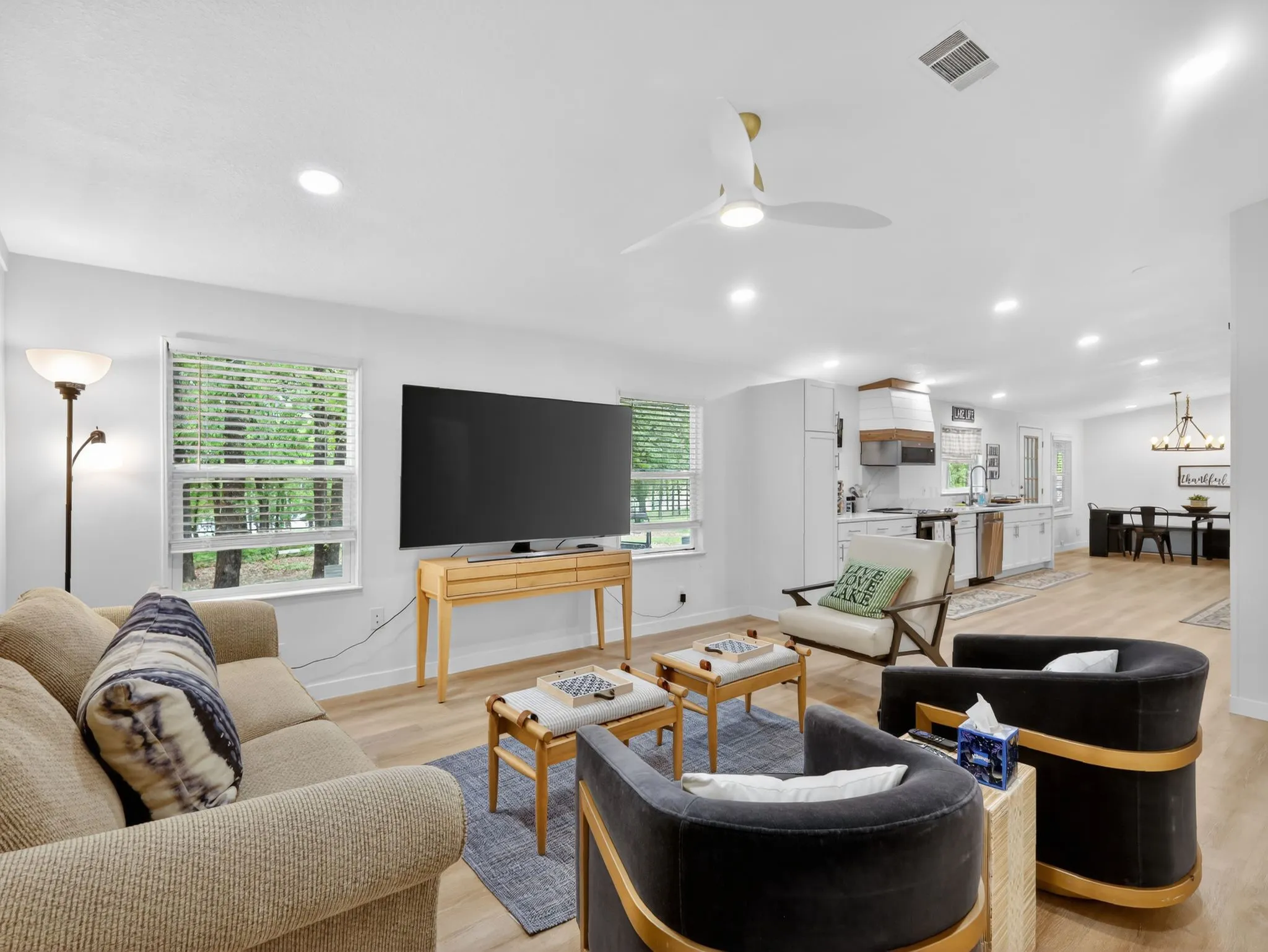 Open-concept living space featuring wood-finish flooring, recessed lighting, and a white ceiling fan