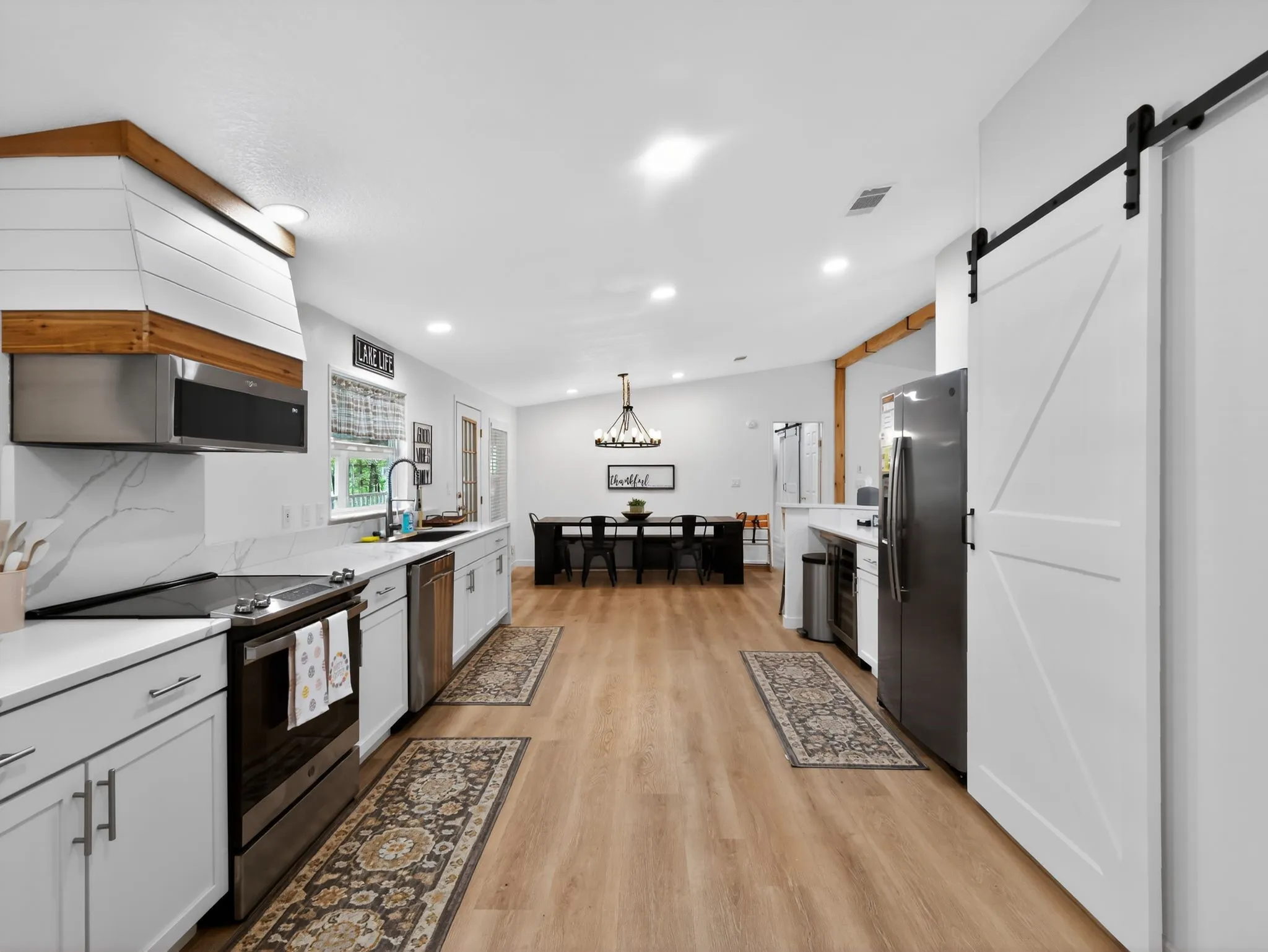 Open-concept kitchen and dining area featuring light wood-finish flooring