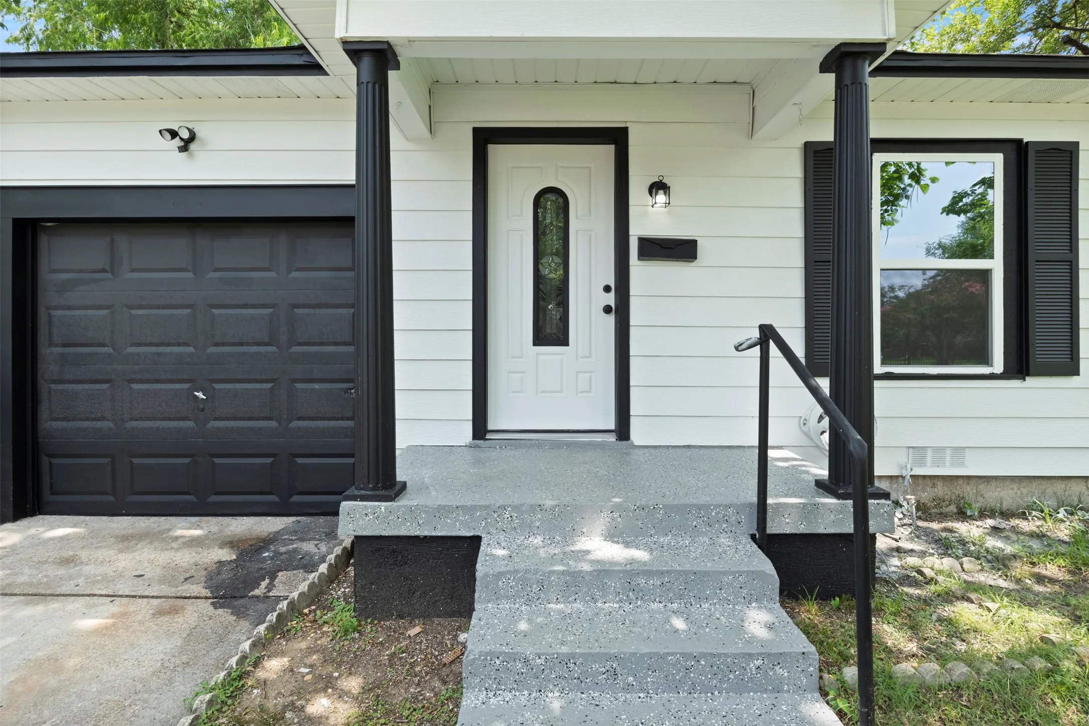 Crisp white siding with black trim accents the exterior