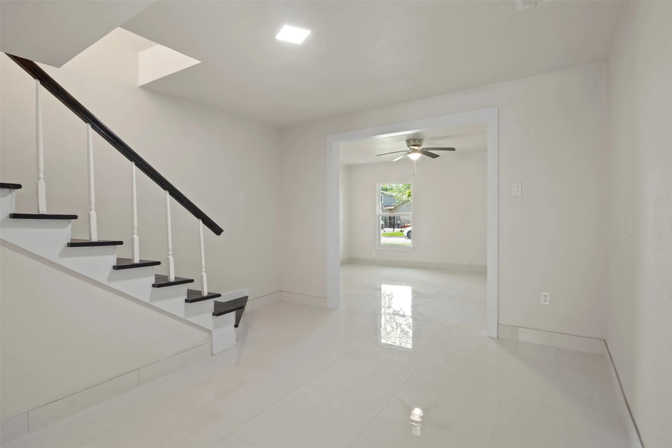 Two-tone staircase with dark treads and white risers, complemented by a dark handrail and white spindles