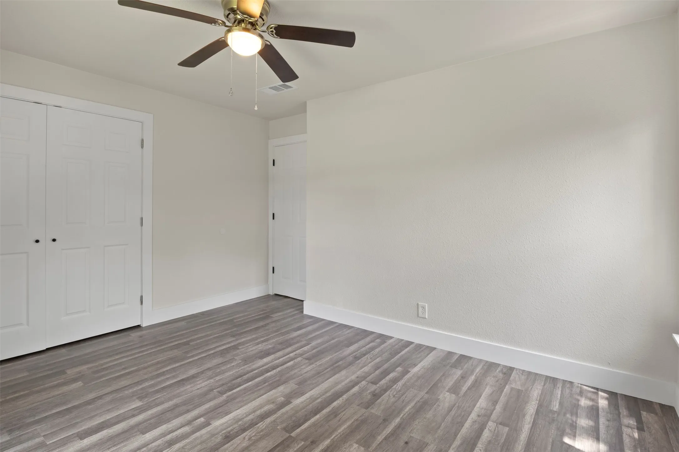 Room featuring neutral wall finishes and wood-finish flooring