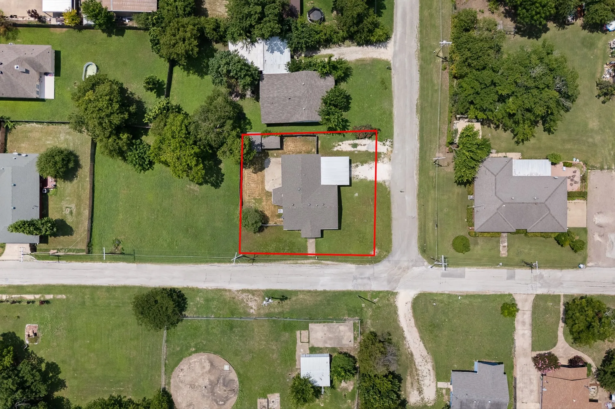 Residential property positioned on a corner lot, featuring mature trees and established landscaping
