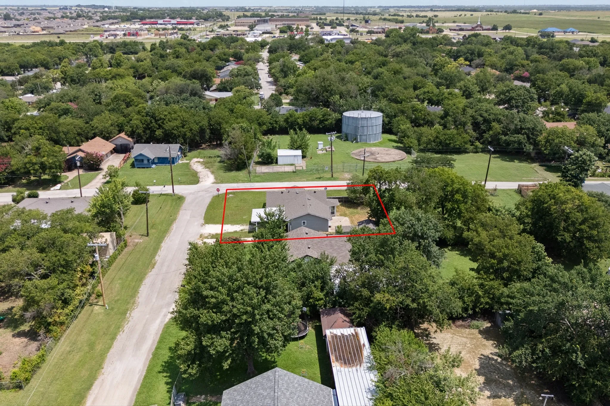 Aerial perspective showcasing a property with a grey siding exterior and a dark shingle roof