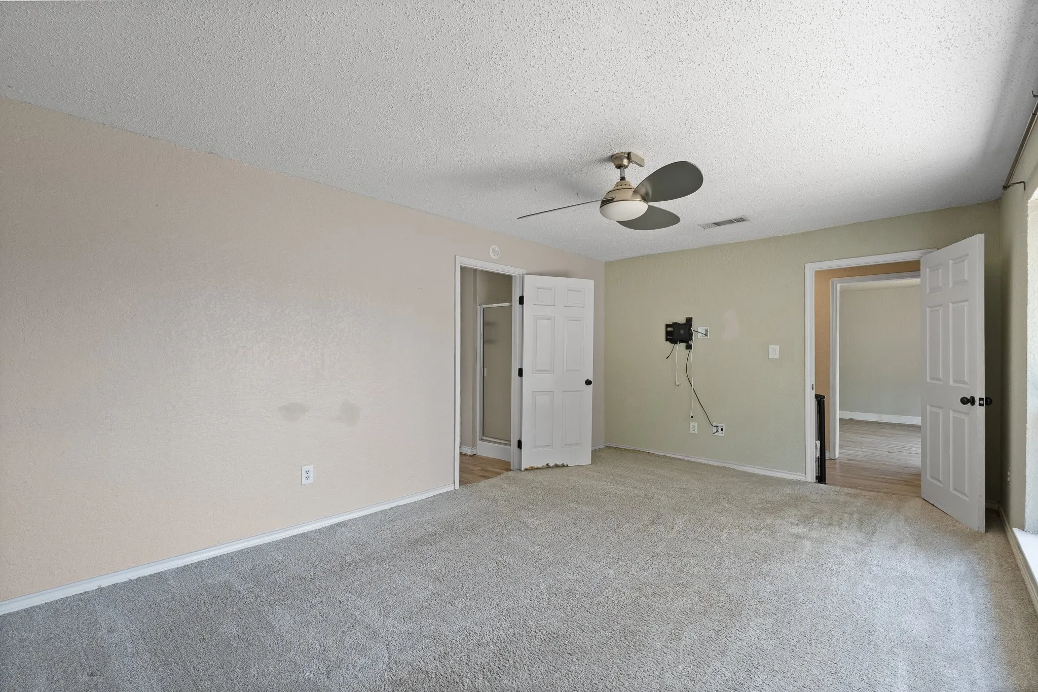 Carpeted room with a ceiling fan, baseboard molding, and white paneled doors