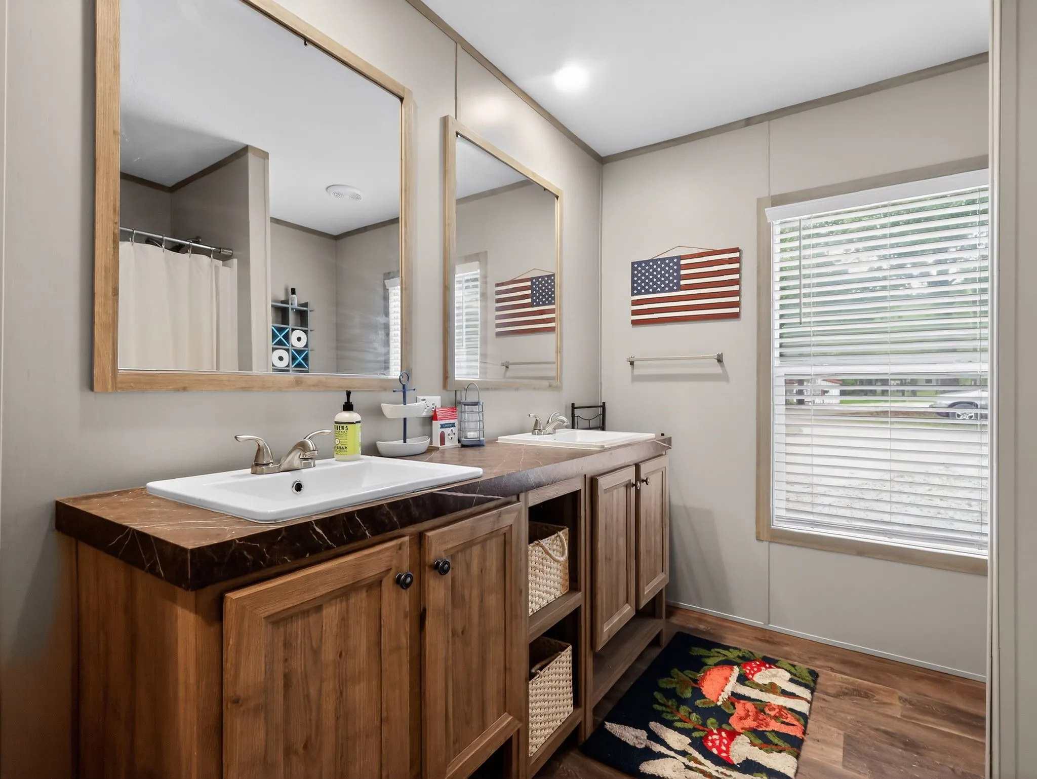 Dual vanity featuring wood-finish cabinetry, white rectangular sinks, and a laminate countertop