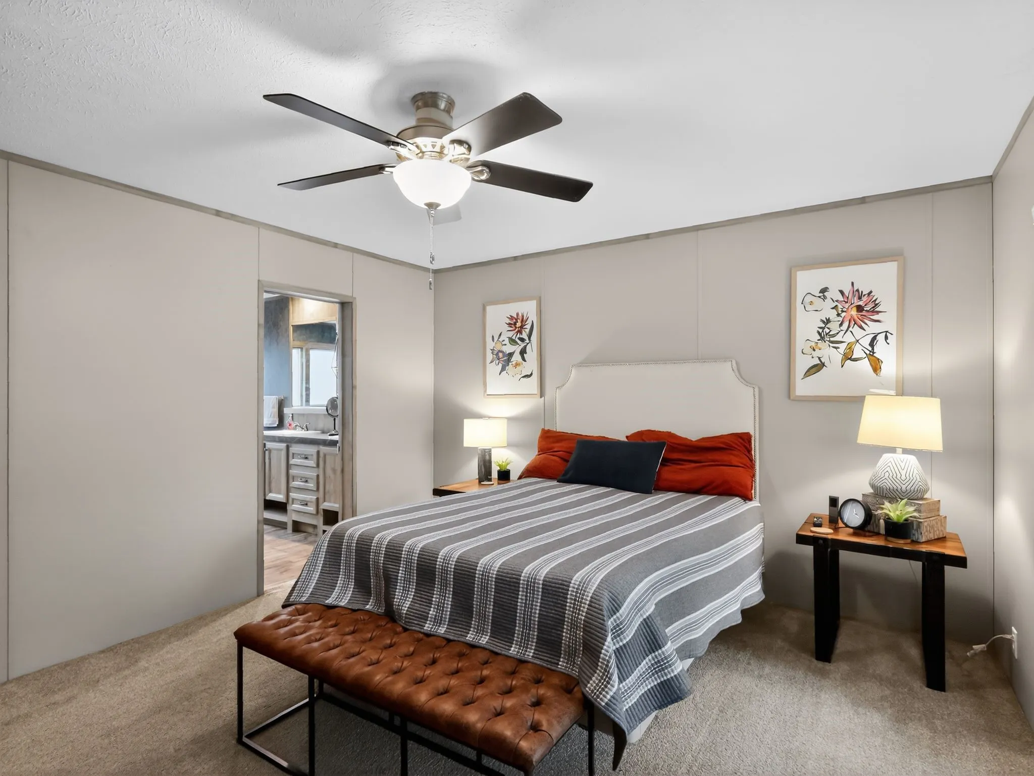 Carpeted bedroom with a ceiling fan light fixture and an upholstered headboard