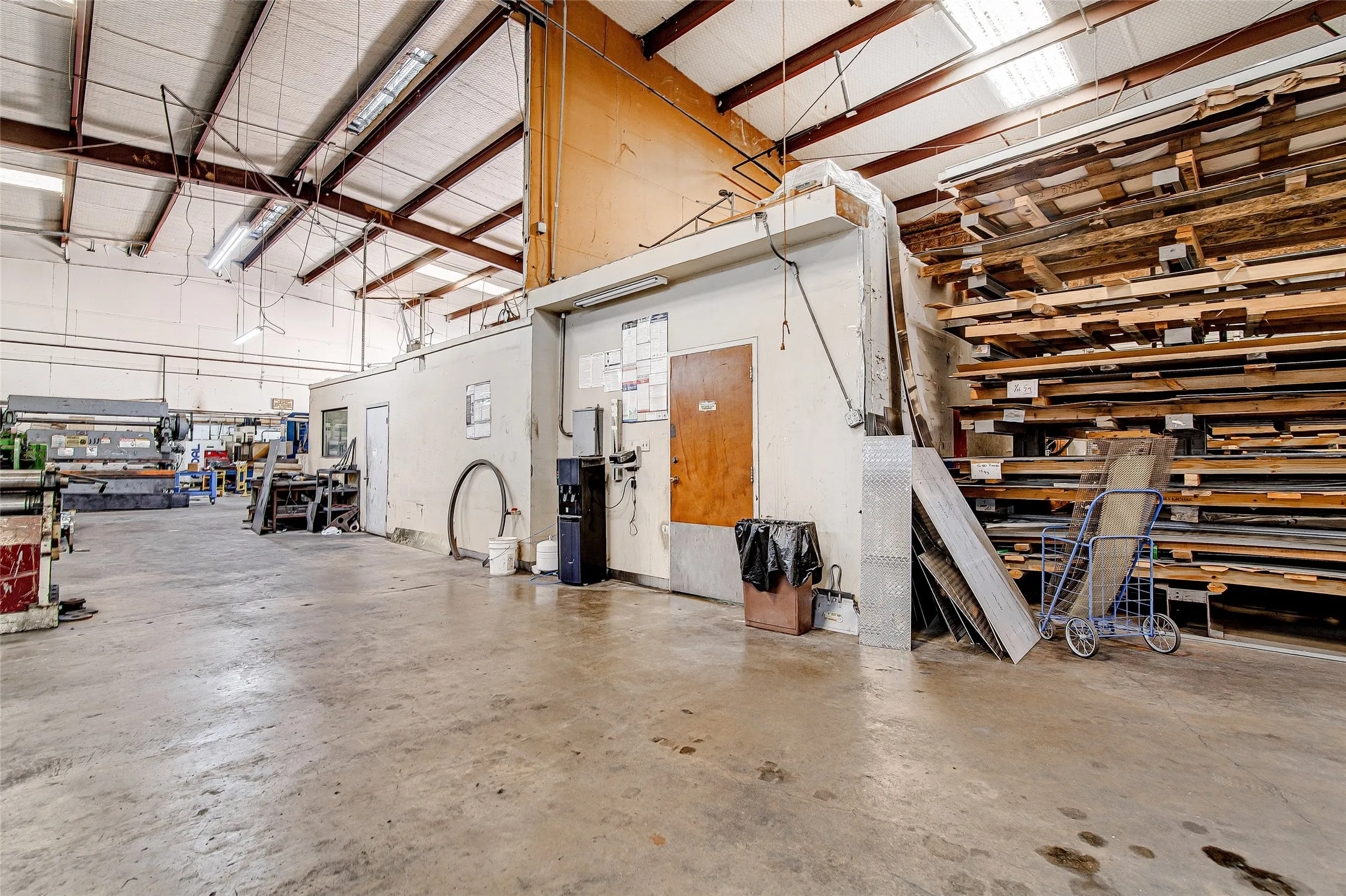 Spacious industrial workspace featuring exposed beam ceilings and concrete flooring