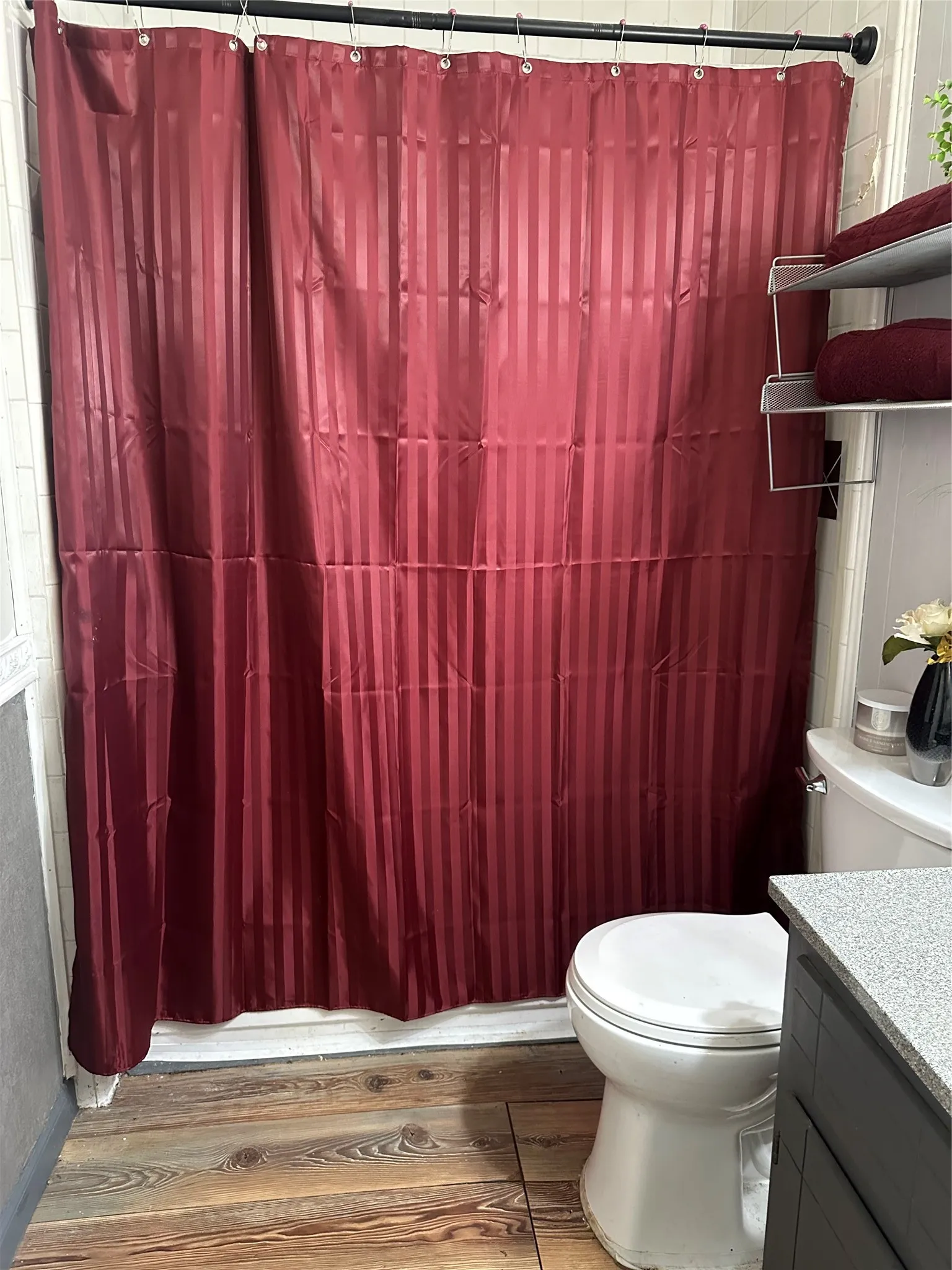 Bathroom featuring wood-finish flooring, a white toilet, and a dark vanity with a light-toned countertop