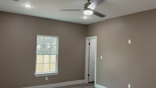 Interior room with neutral-toned walls, a white-framed window, and a white six-panel door