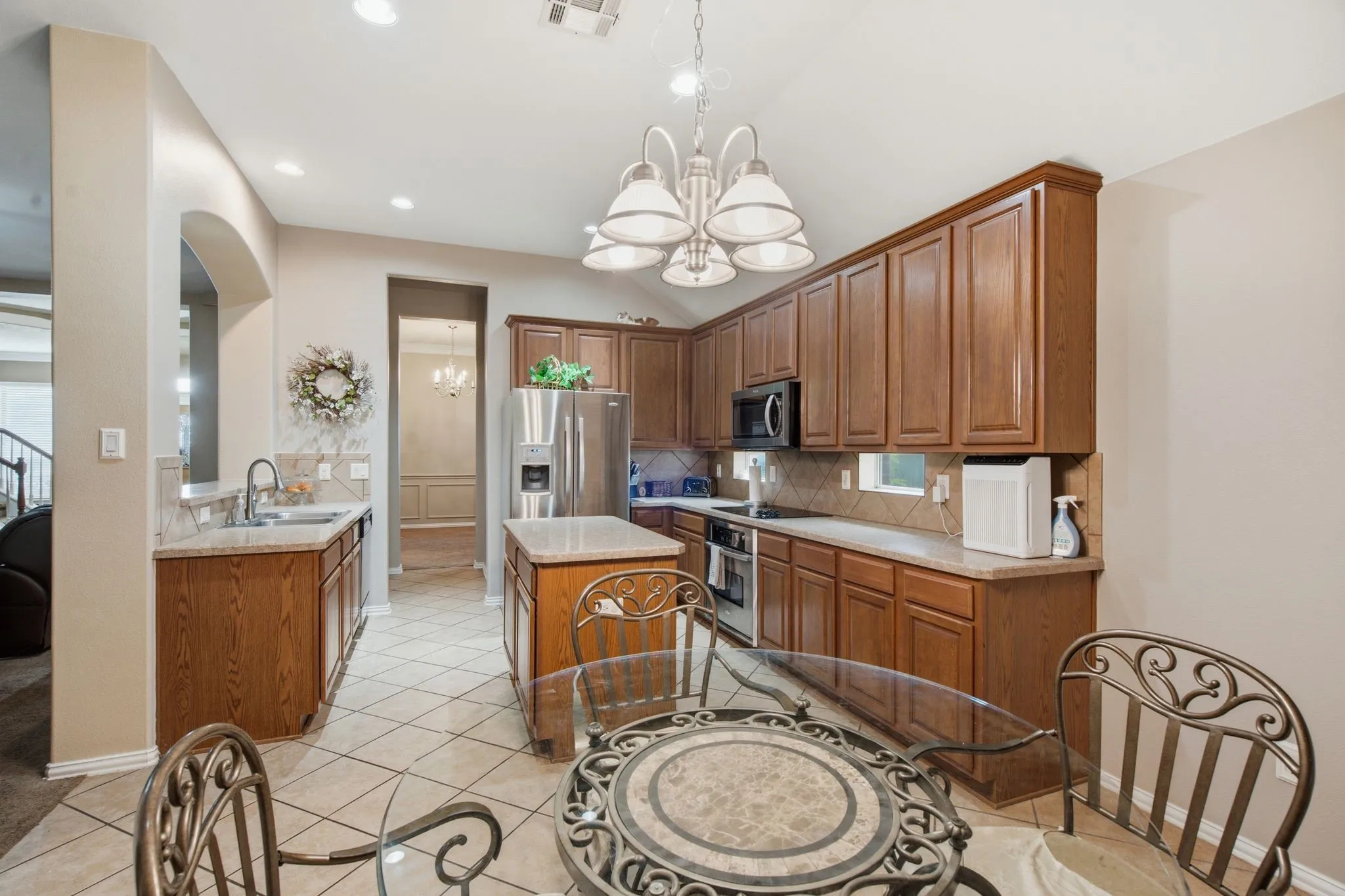 Kitchen featuring a breakfast nook, wood cabinetry, light-toned countertop surfaces, recessed lighting, and a tile backsplash