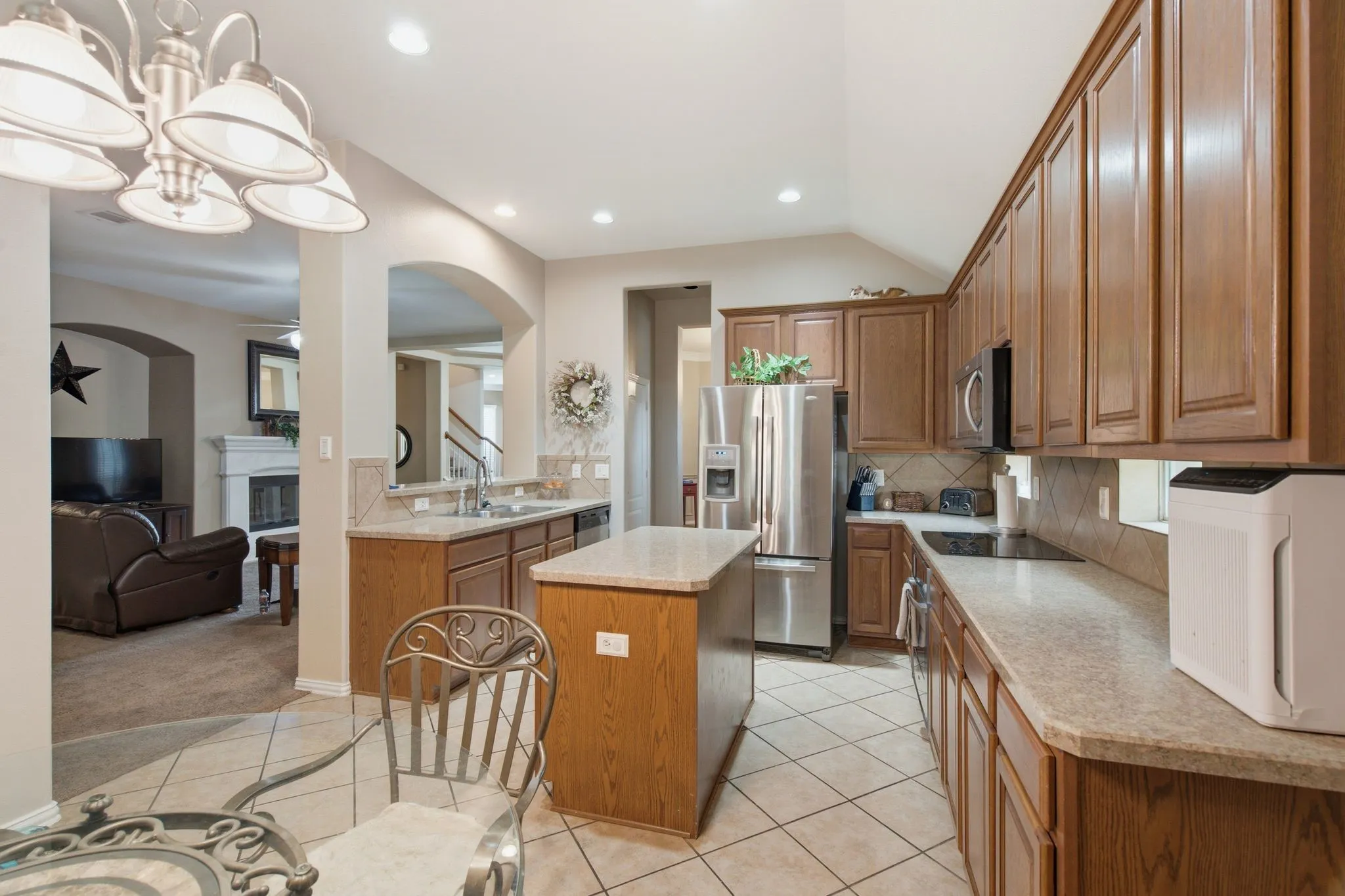 Kitchen featuring a central island, light-toned countertops, and extensive wood cabinetry