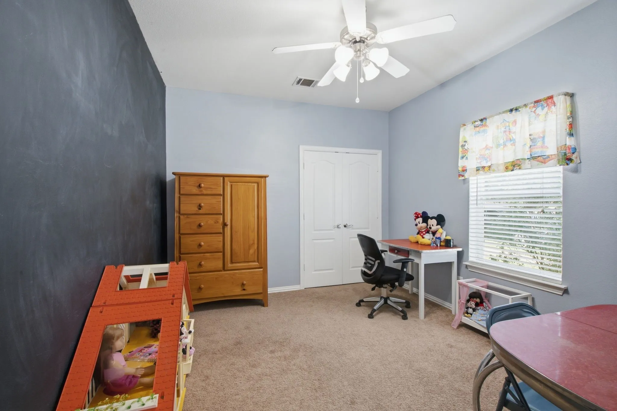 Interior room featuring light blue walls, a dark accent wall, and neutral carpet flooring