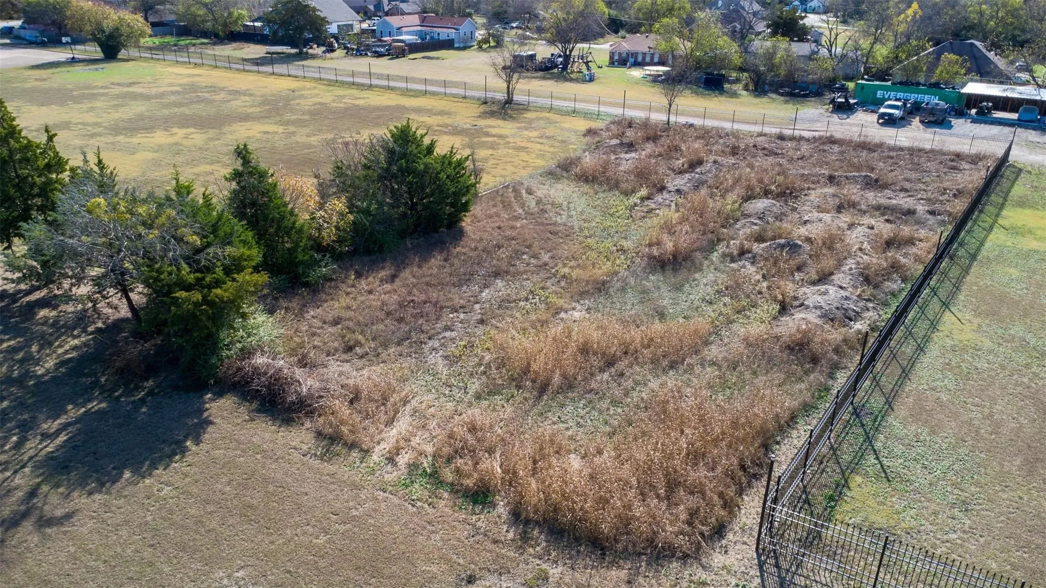 Expansive land parcel featuring existing perimeter fencing and mature trees