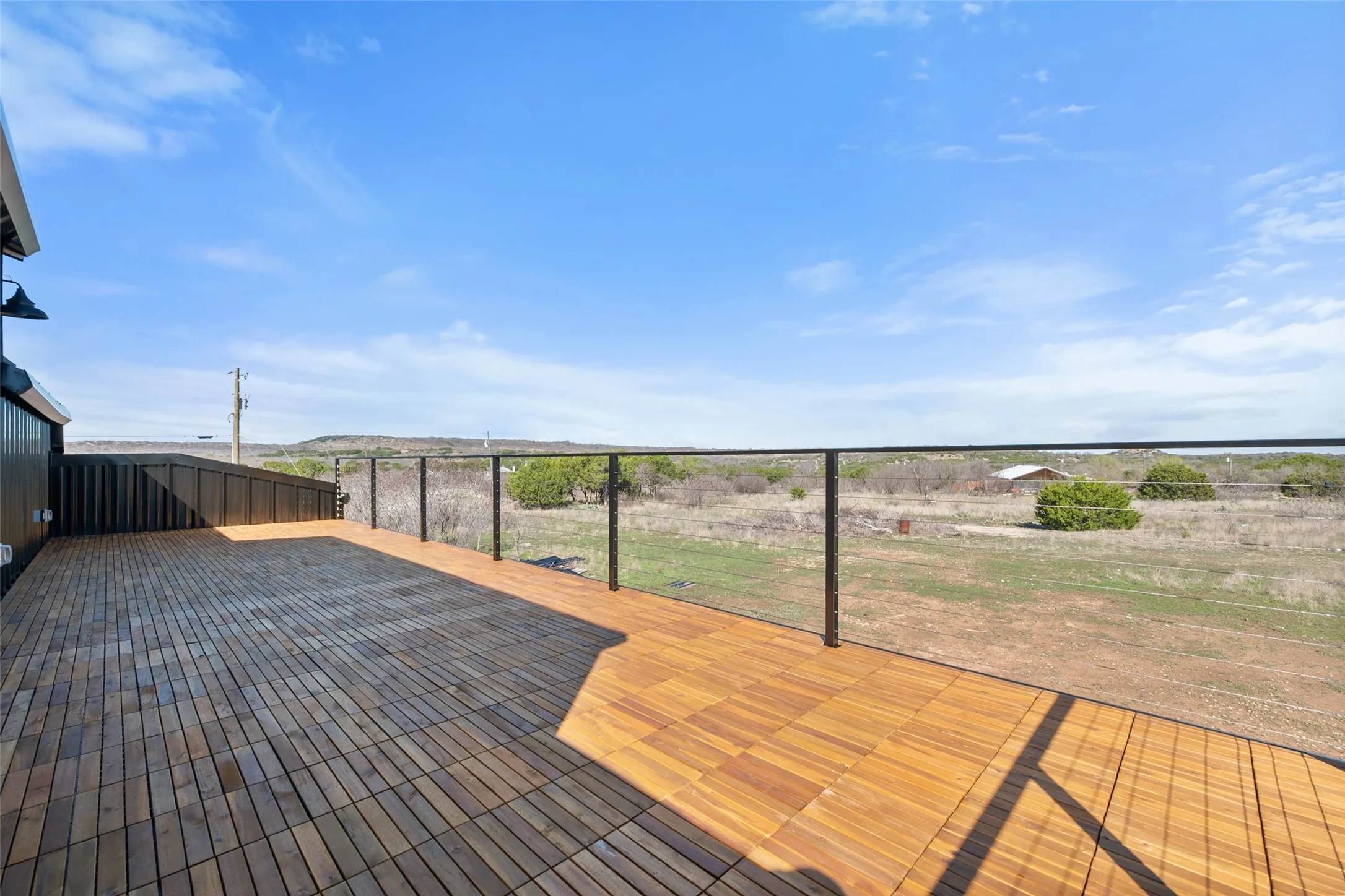 Expansive wood-finish deck with cable railing