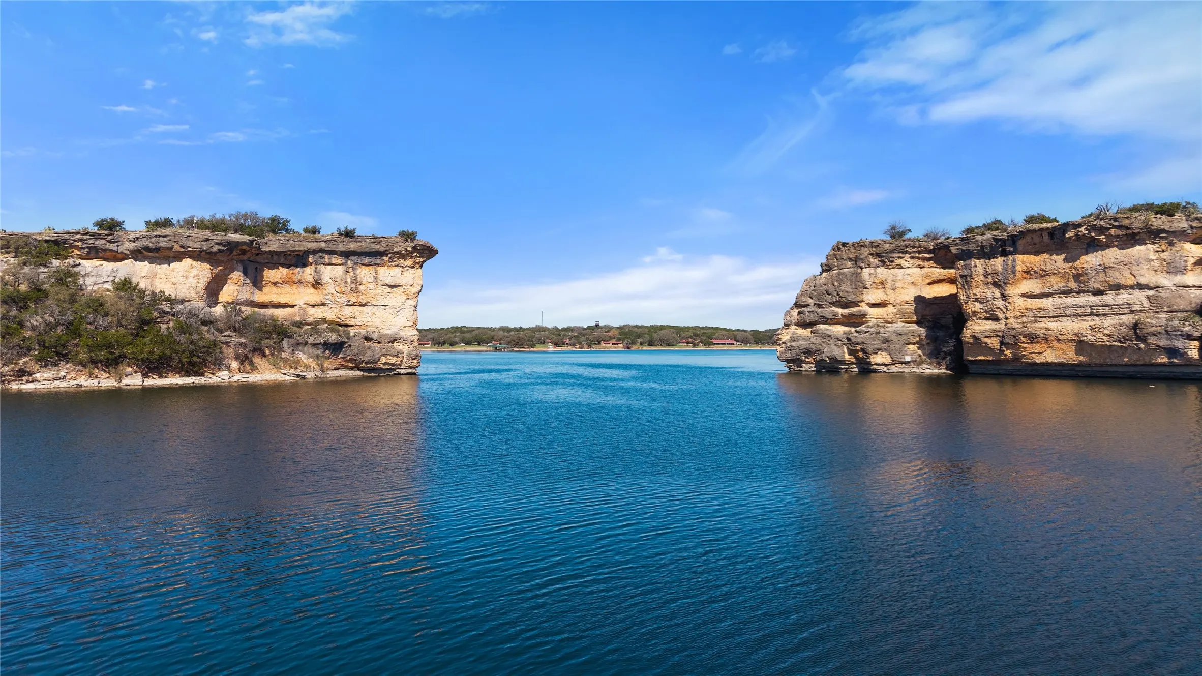 Expansive waterfront property featuring rugged cliff faces, mature natural vegetation, and direct water access