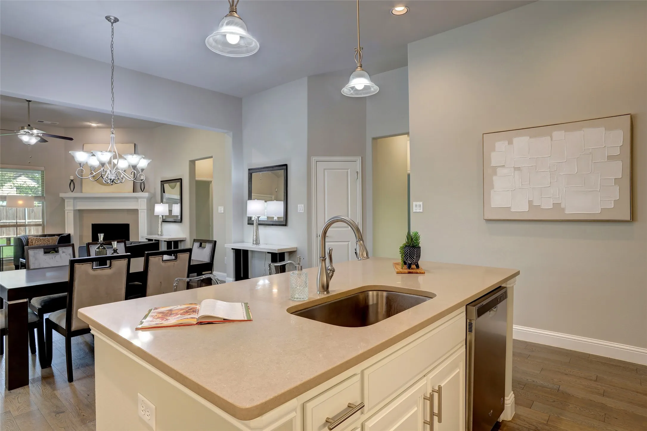 Kitchen island with a stainless steel sink, gooseneck faucet, and integrated dishwasher