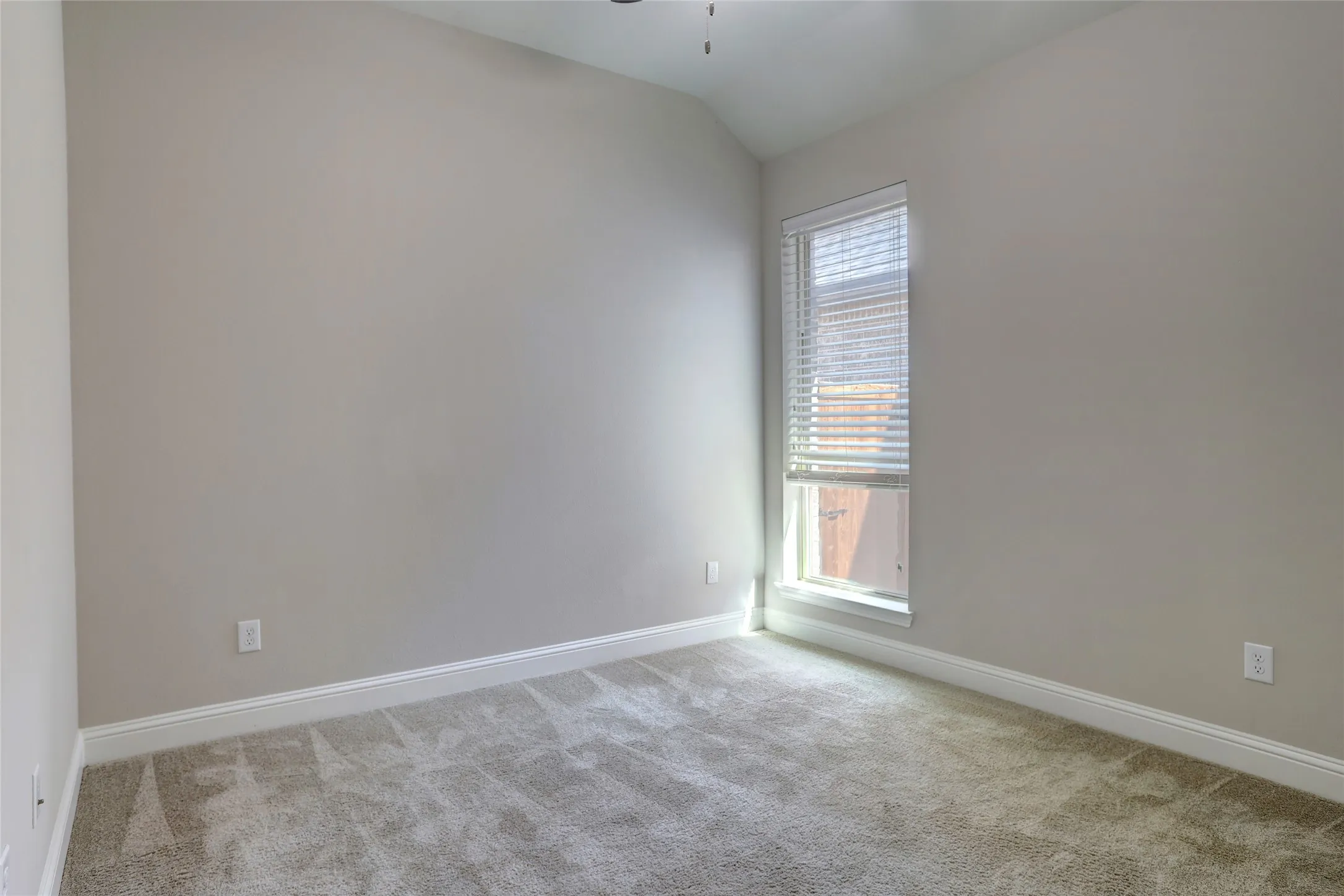 Room featuring neutral wall finishes and a single-pane window with horizontal blinds