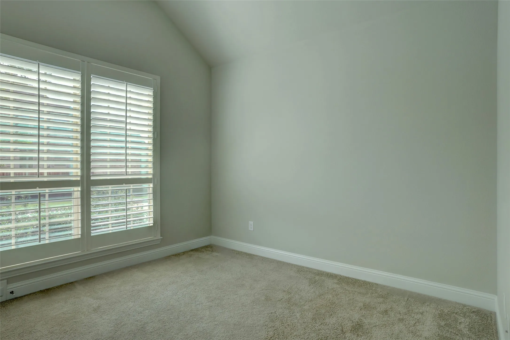 Dual windows featuring white plantation shutters