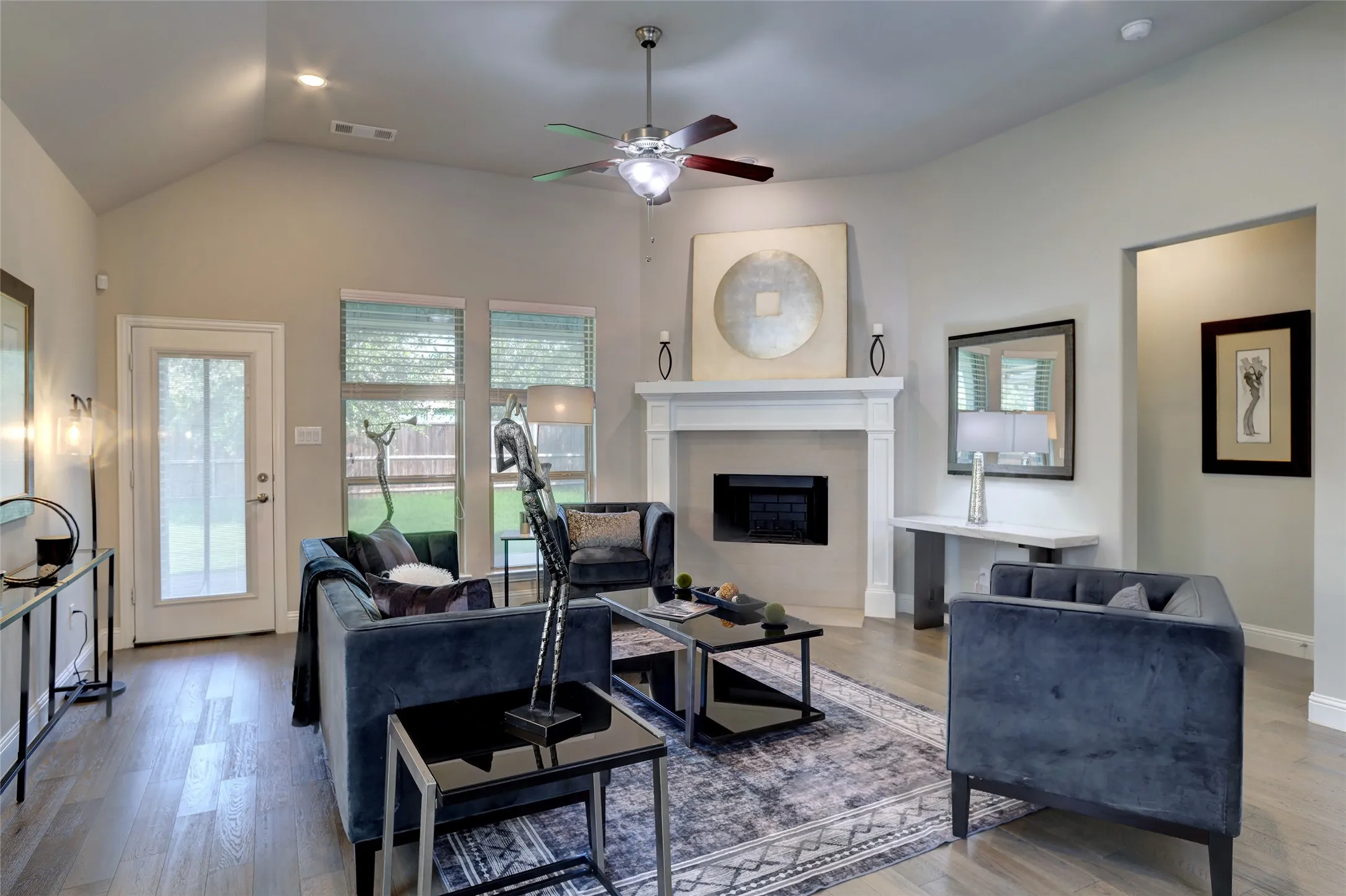 Spacious living area featuring a vaulted ceiling and wood-finish flooring
