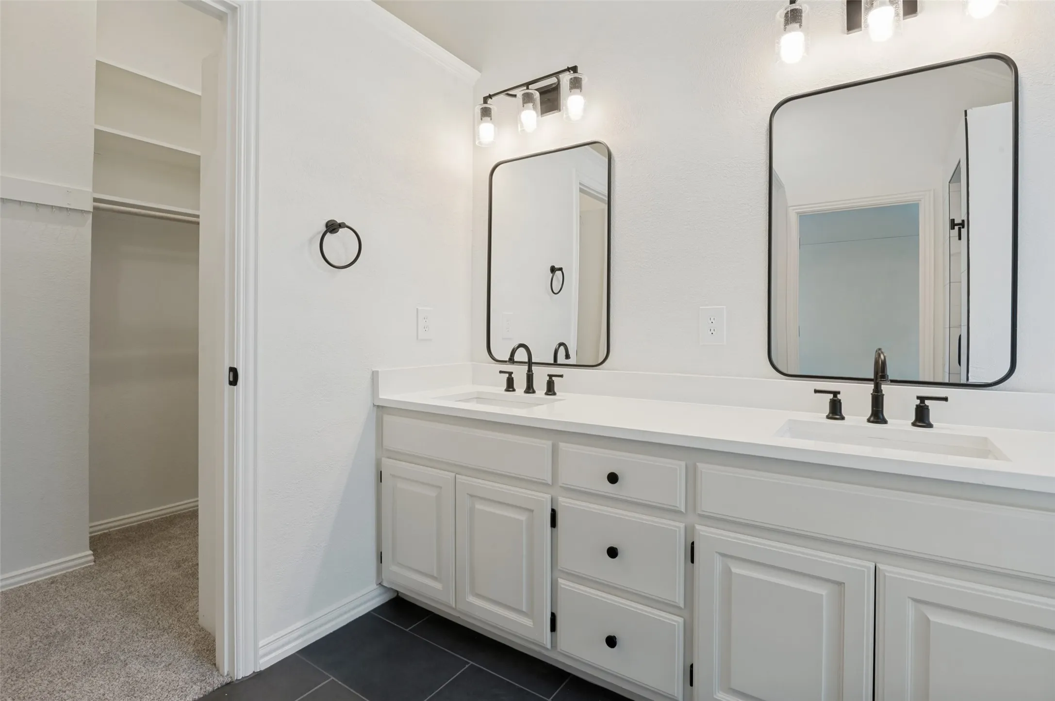 Dual vanity with white cabinetry, matte black hardware, and rectangular undermount sinks