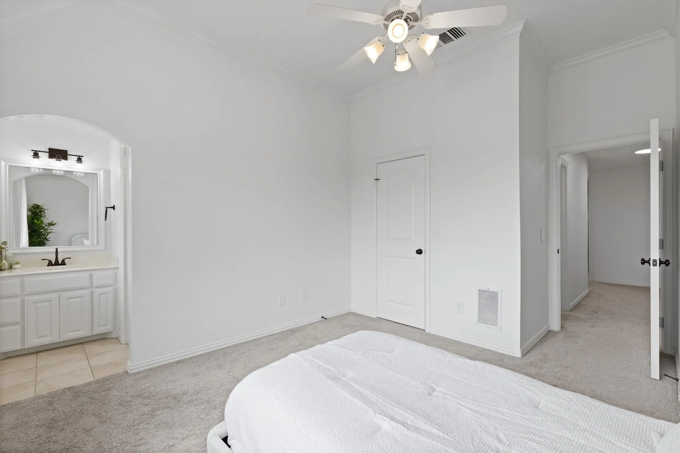 Bright bedroom featuring crown molding and a ceiling fan