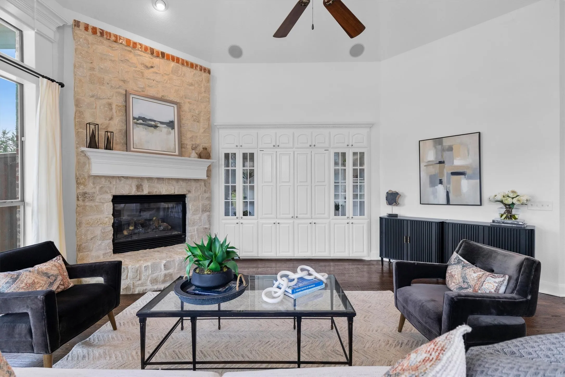 Living area featuring a stone-clad fireplace with a white mantel, an integrated gas insert, and high vaulted ceilings