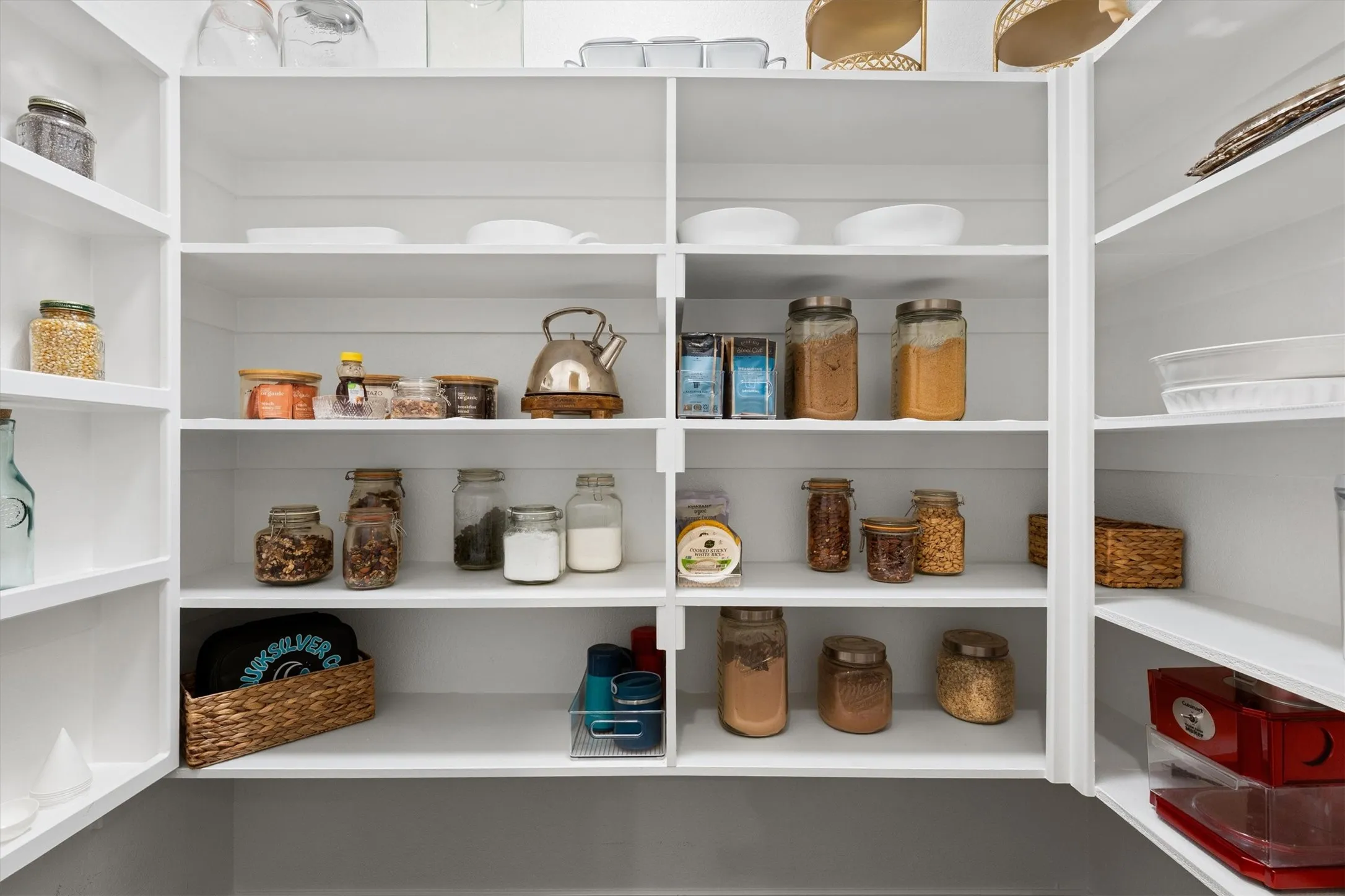 Custom pantry shelving with white finishes providing extensive storage capacity