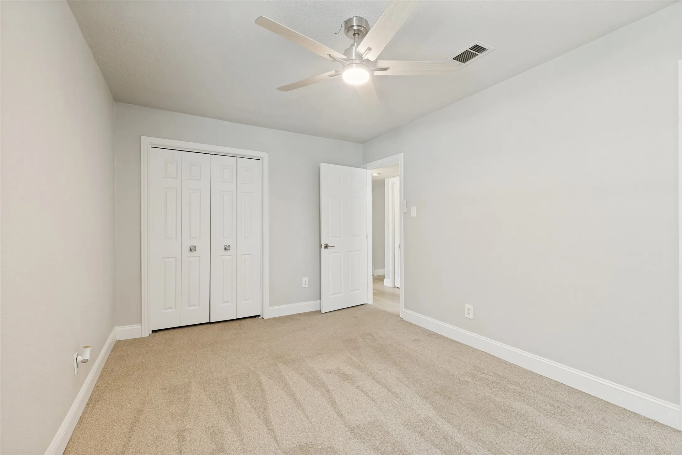 Neutral-toned room featuring light gray walls, white trim, and light beige carpet