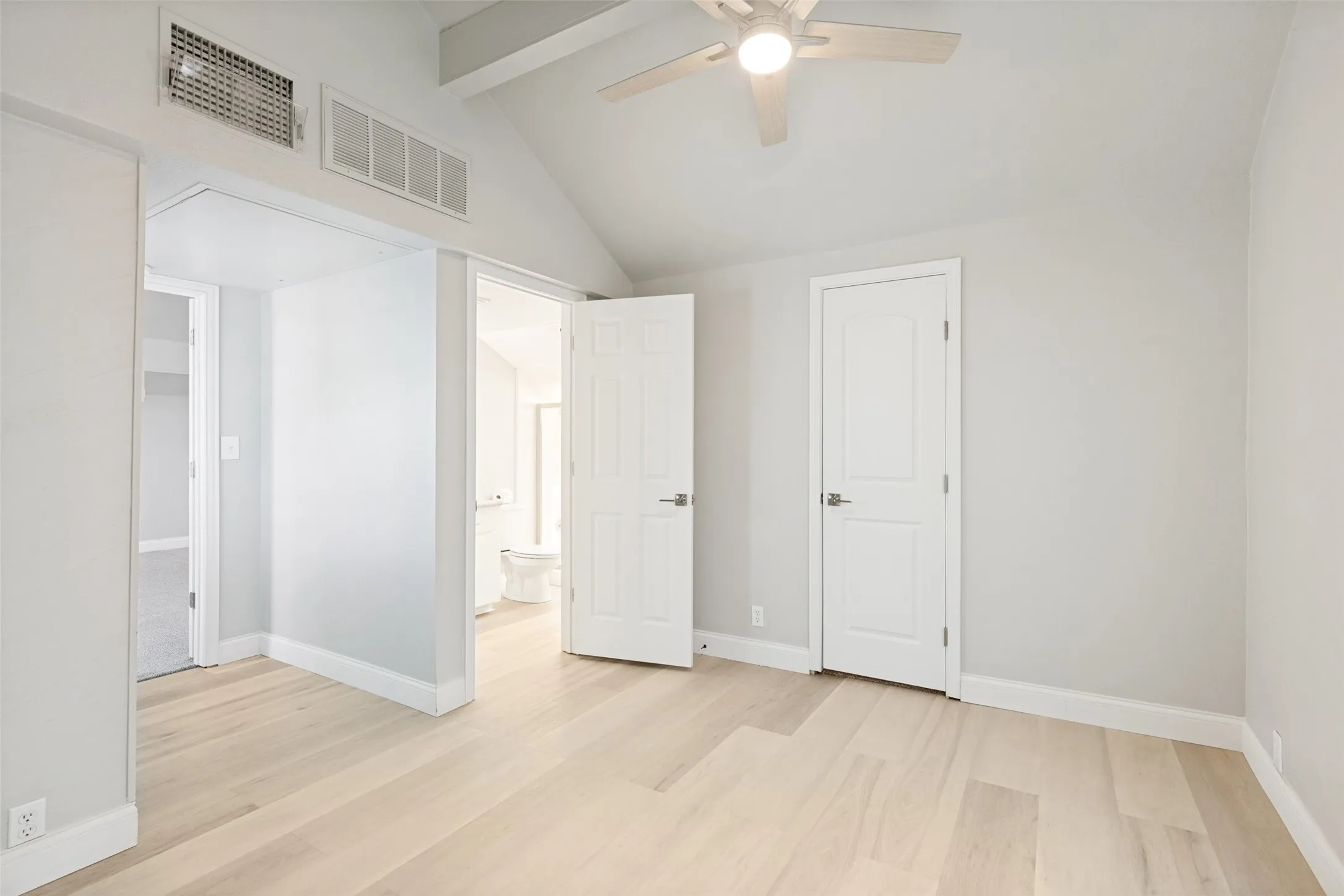 Bedroom featuring light wood-finish flooring and a vaulted ceiling