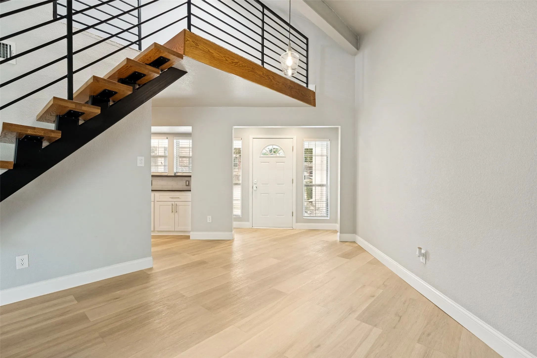 Modern floating staircase with wood-finish treads and black metal railing