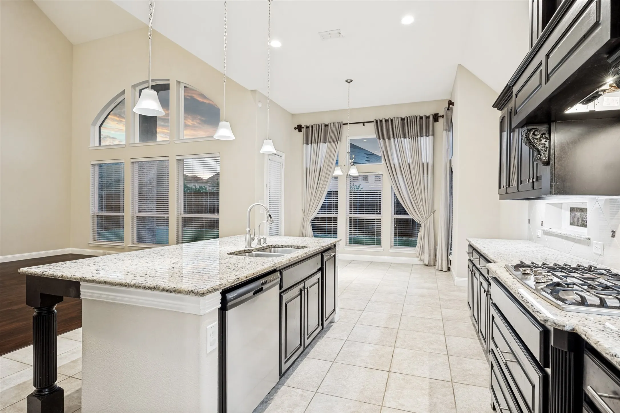 Kitchen featuring granite countertops, dark wood-finish cabinetry, stainless steel appliances, and a gas range
